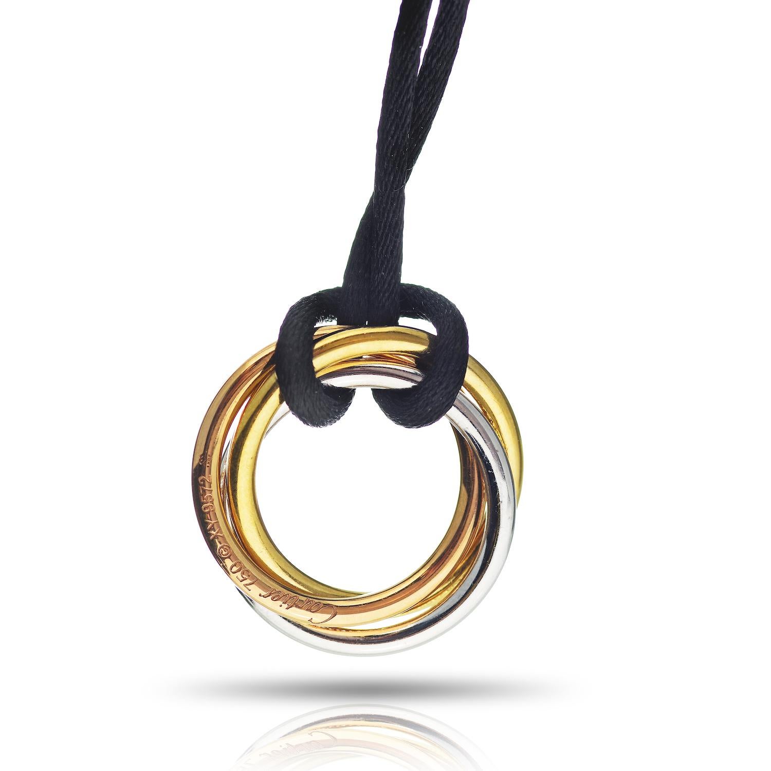 This magnificent pendant from Cartier's Trinity collection is made in 18k yellow, white, and rose gold and pave-set with 144 diamonds of an estimated 1.29 carats. Completed with an adjustable black cord. Simply stunning. Circa 2013. Cartier