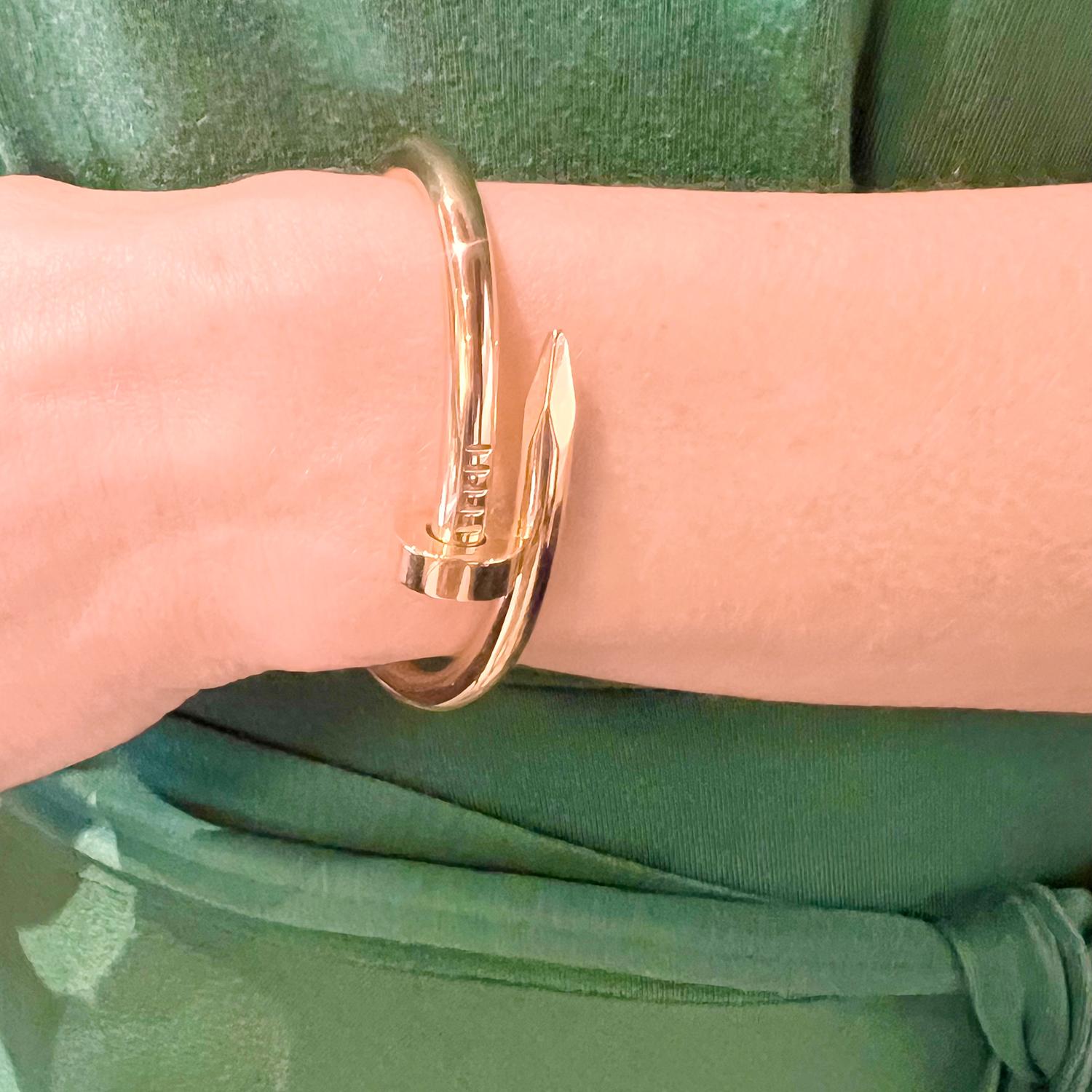 Cartier Juste un Clou bracelet in 18k rose gold. This bangle encircles the wrist in a 6mm thick nail head design with a polished finish. Hinged at the back with a hidden closure near the nail head at top.  Interior signed '© Cartier 16' with serial