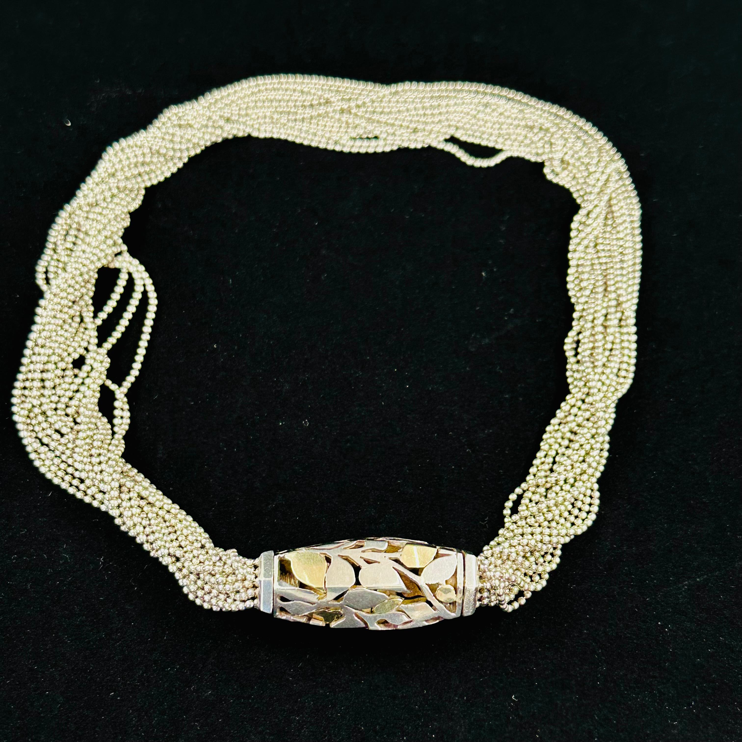 Cartier 18k & Sterling Silver Multi Strand Abstract Barrel Motif Necklace and it is stunning.
The Multiple intertwined strands hang beautifully. The abstract barrel centerpiece is Hand Made ornately designed and made from both 18k yellow gold and