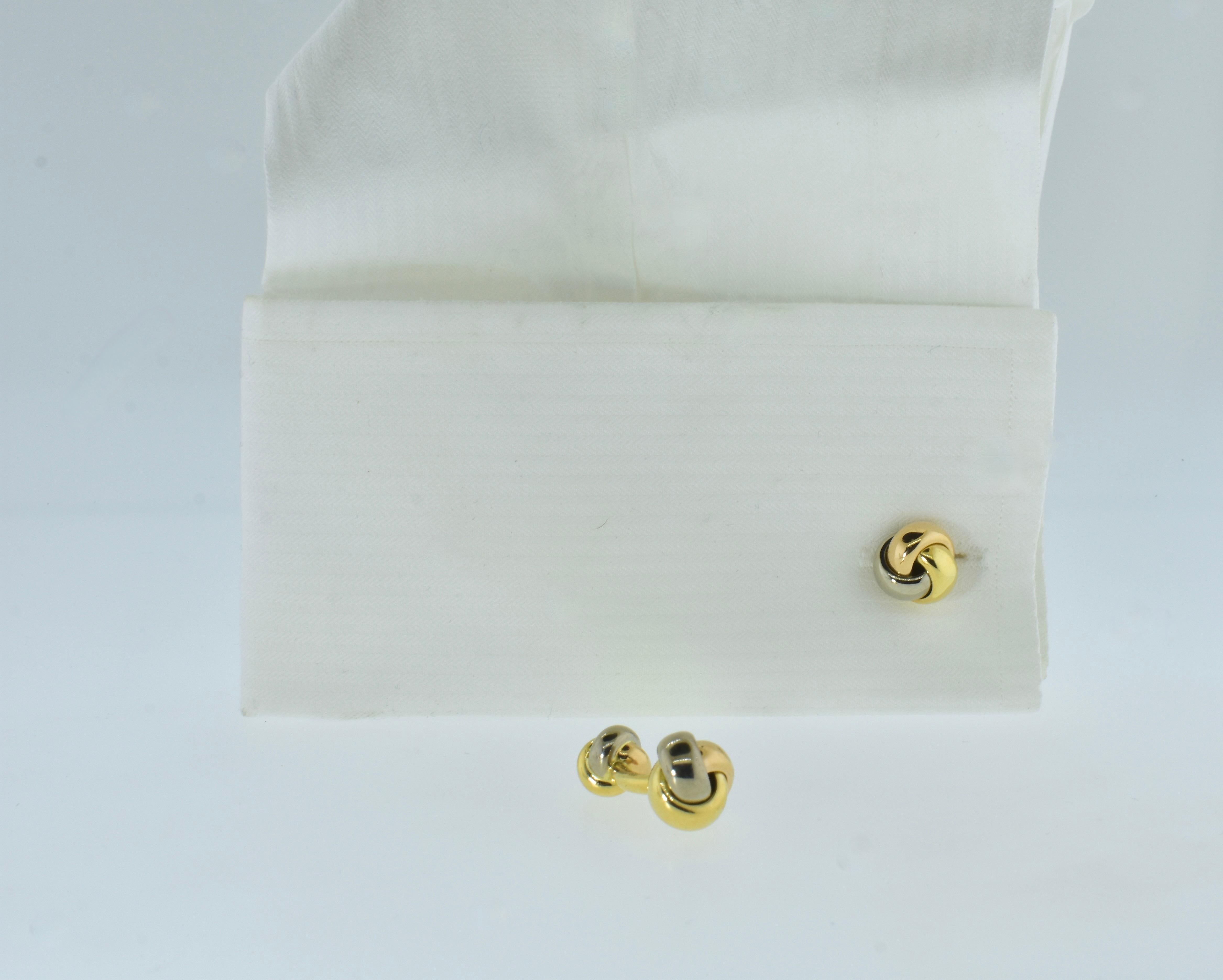 Cartier cufflinks 18K tri-color gold, pink, white and yellow, back to back  of love knots, one large the other smaller.  Signed by Cartier, numbered and marked 750 for 18K, these cufflinks weigh 21.6 grams or about 2/3 of a troy ounce and are