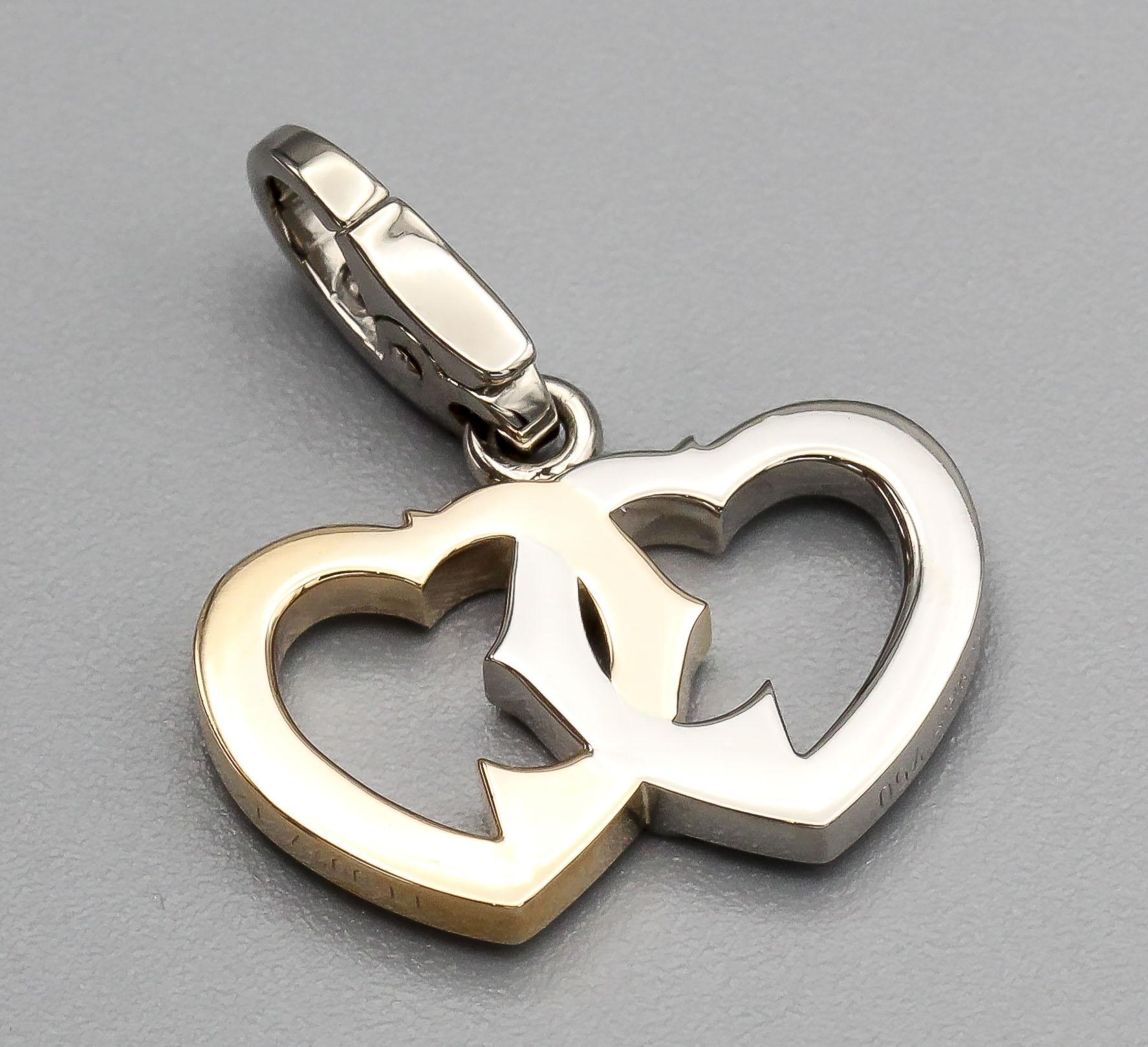 La breloque logo double cœur entrelacé en or blanc et rose 18 carats de Cartier est un bijou éblouissant et symbolique qui incarne à merveille l'essence de l'amour et de l'élégance. Fabriquée avec un grand souci du détail par la célèbre marque de