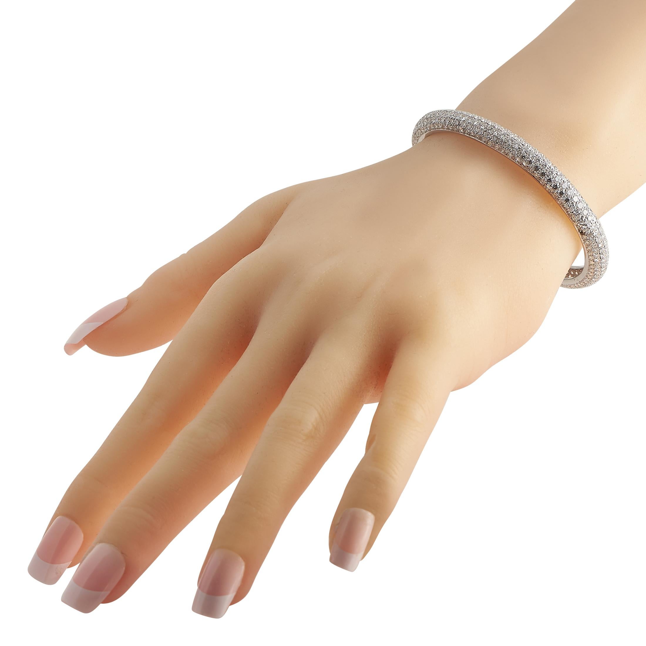 A versatile and brilliant jewel to adorn your wrist on those special days. This Cartier Etincelle bangle features a rigid bracelet in solid 18K white gold embellished with hundreds of round diamonds in pav setting. The bracelet measures 7 inches and
