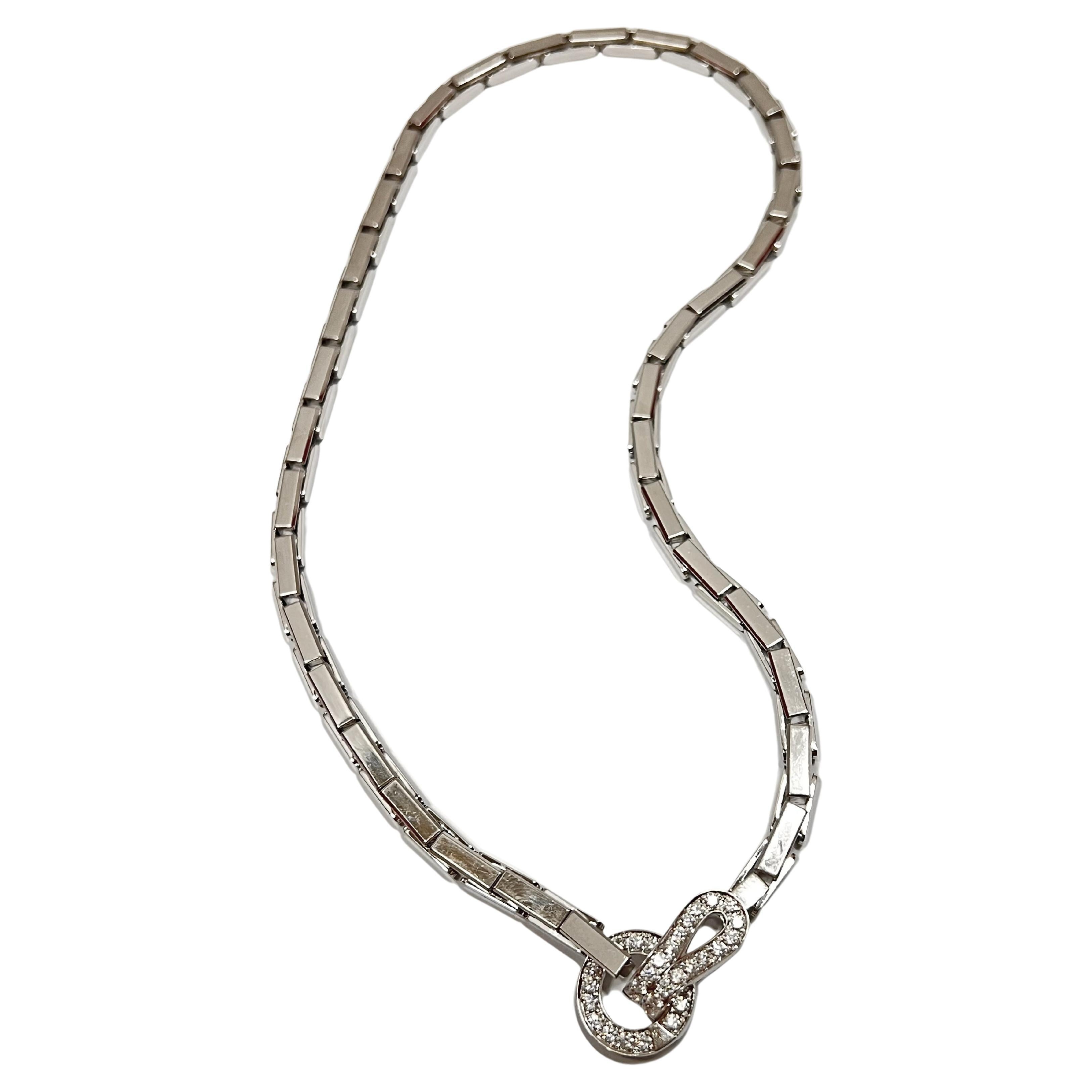 Cartier 18kt white gold and diamond necklace from the Agrafe Collection, featuring polished rectangular links centering a circular buckle design front clasp, accented by thirty-four round brilliant-cut diamonds totaling approximately 1.10 carats