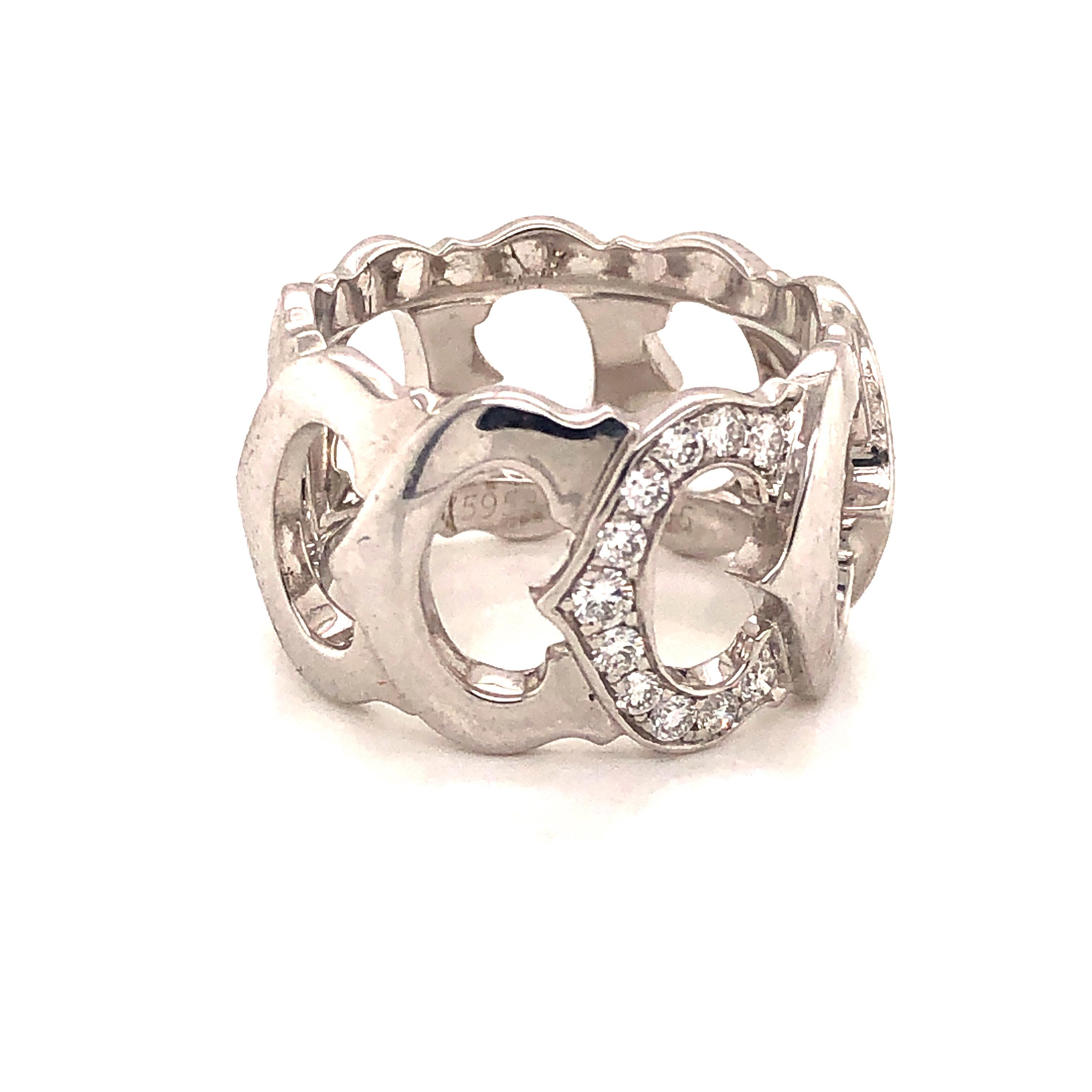 Cartier White Gold Diamond C Logo Ring size 55 or 7.25. The ring is crafted of 18 karat white gold and features a band of C motifs with a single center C set with round brilliant cut diamonds weighing approximately .20 total carat weight. This is a