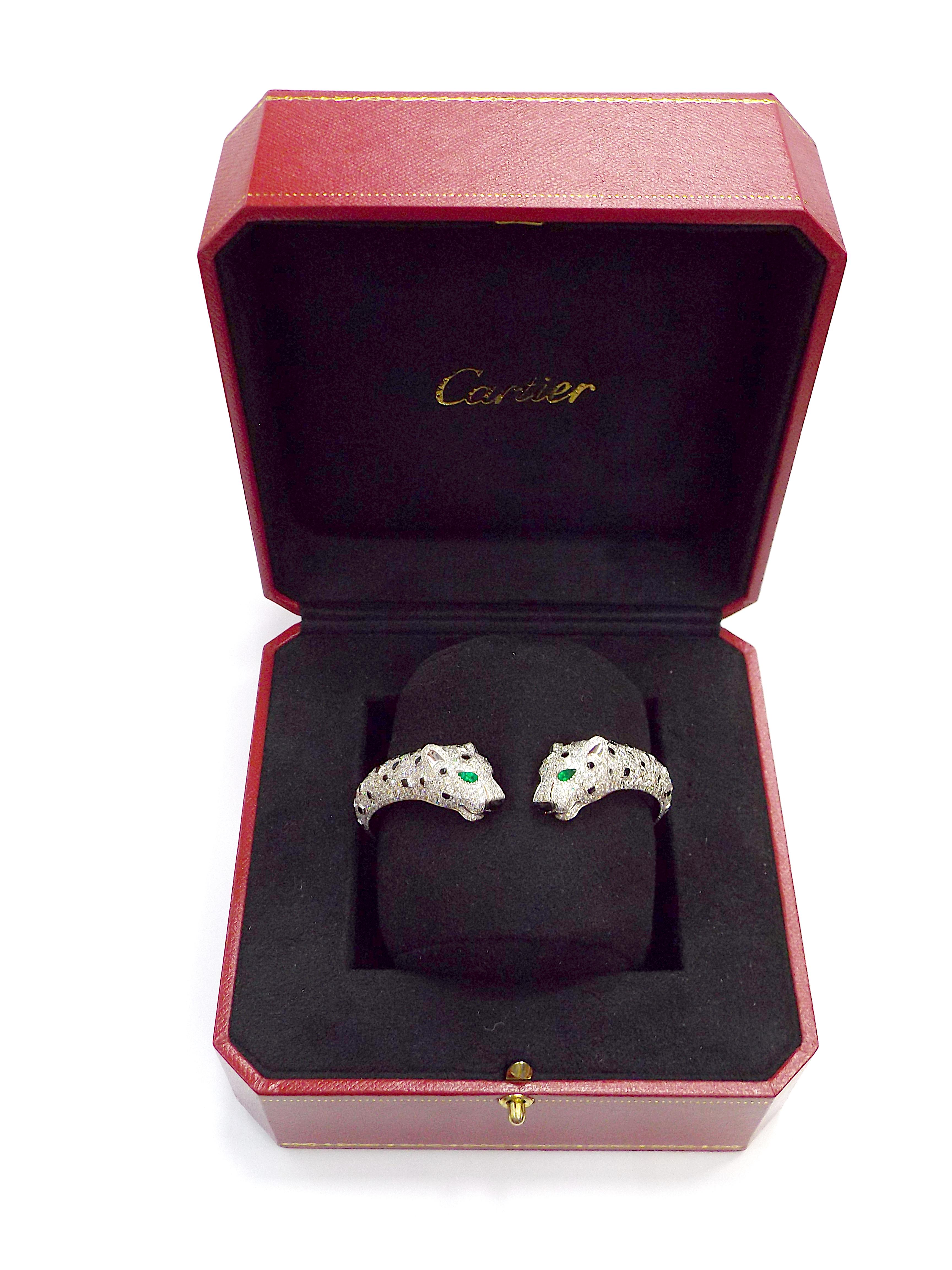 Ein einzigartiges Armband von Cartier aus der Collection'S Panthere mit hohem Schmuckwert. Entworfen als einander zugewandte Zwillingspanther, besetzt mit ap. 14 Karat Diamanten, gefasst in 18 Karat Weißgold, mit Smaragdaugen und Onyxnasen. Der