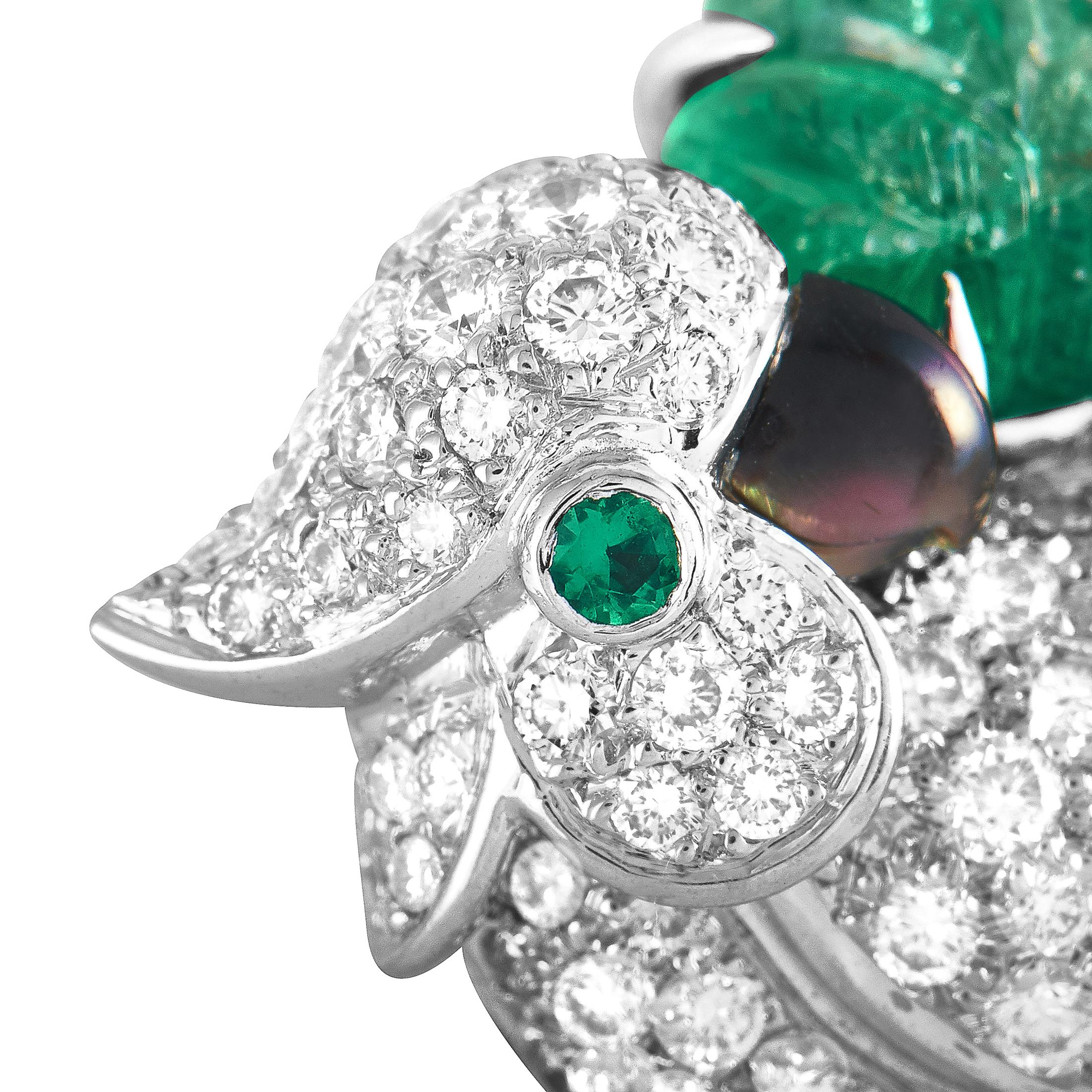 This Cartier bird pendant is crafted from 18K white gold and embellished with diamond, emerald and sapphire stones. The pendant weighs 8 grams and measures 1” in length and 0.70” in width.

Offered in estate condition, this item includes the