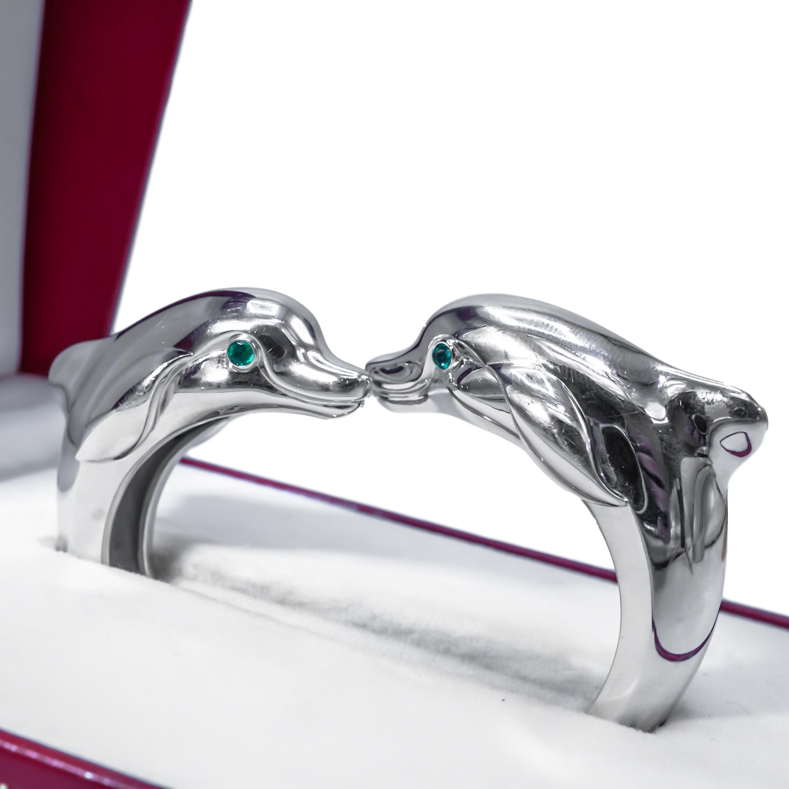 White Gold Dolphin Bangle Bracelet, Cartier
18 kt, the polished bangle designed as a pair of confronting dolphin heads, accented by emerald eyes, signed Cartier, no. 753 749, approximately 59.2 dwts. Inner circle 6 1/8 inches. With signed box.