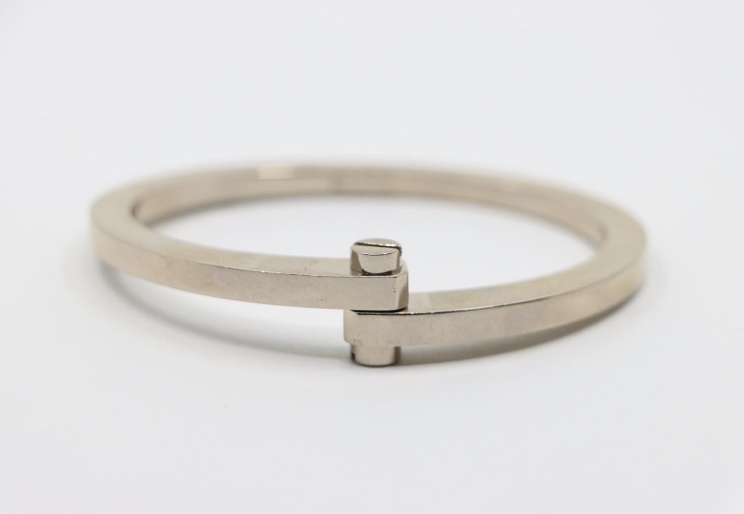 Cartier 18K White Gold Menotte Bracelet
With the Open Key

Marked:
Cartier
750
B07141

Approximate Dimensions:
Size 01
14.3 cm ( Length)  
0.3 - 1.3 cm (Width) 
49.9 grams in weight.