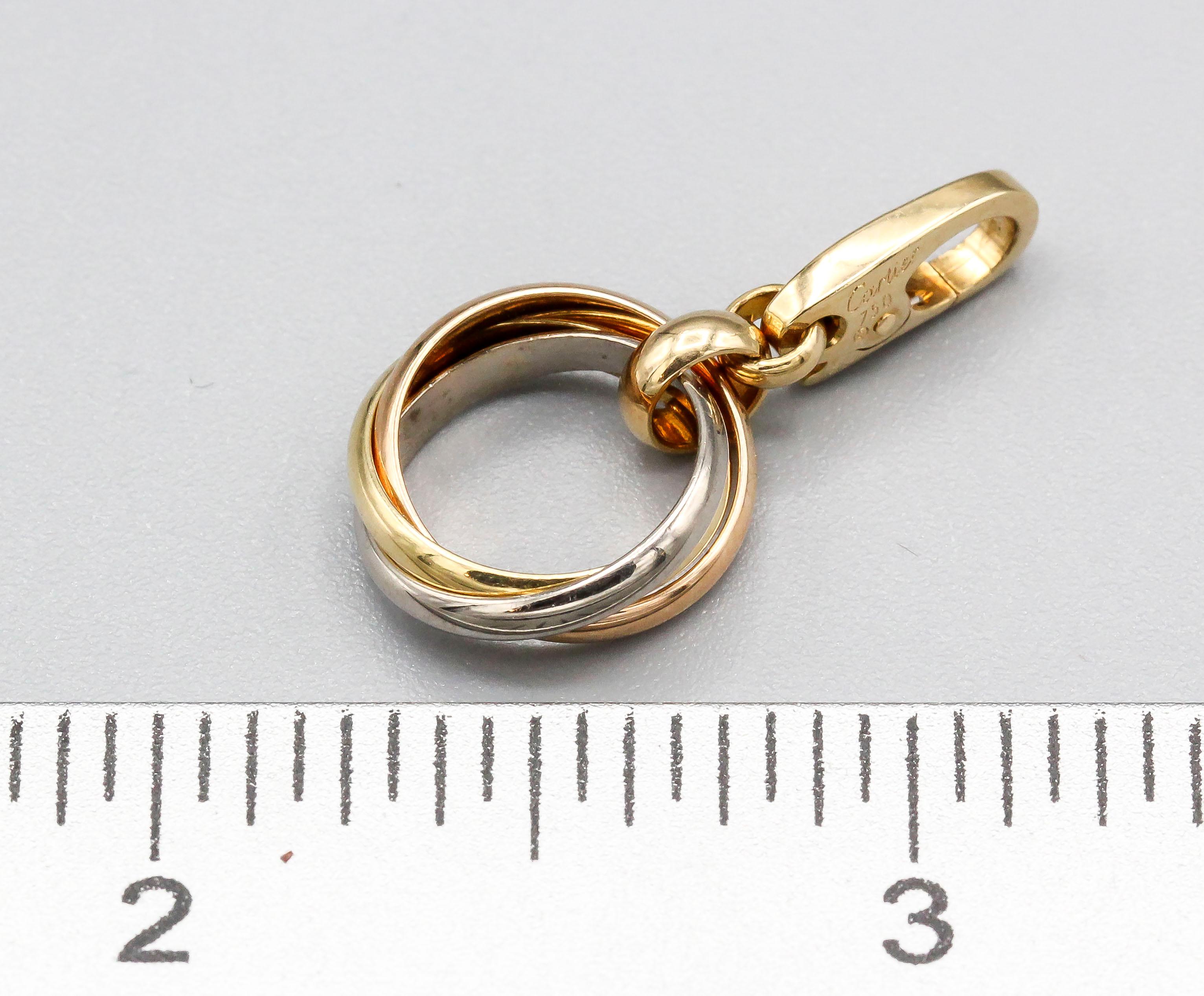 Rare 18K white, yellow and rose gold charm pendant by Cartier. It resembles a Cartier trinity ring.

Hallmarks: Cartier, 750, reference numbers, maker's mark.