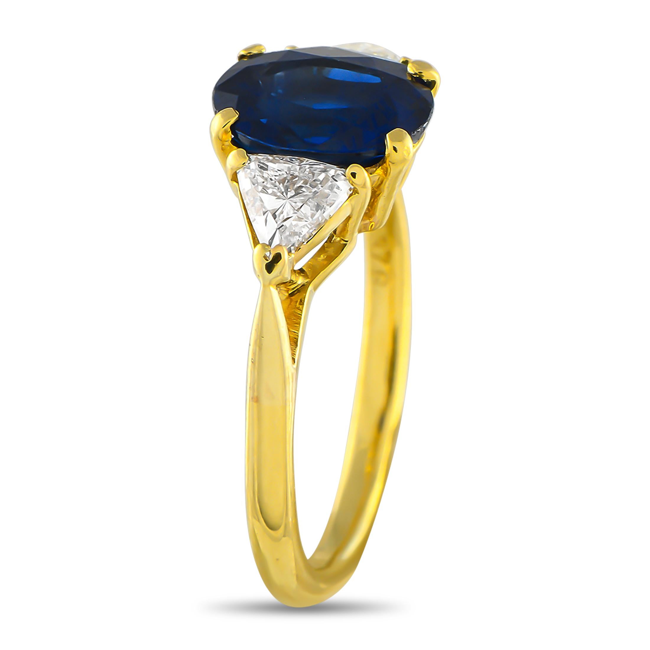 Cette bague classique à trois pierres de Cartier respire l'élégance intemporelle. Au centre de la délicate monture en or jaune 18 carats se trouve un saphir ovale de 3,20 carats certifié par la GIA. Des diamants triangulaires d'un poids total de