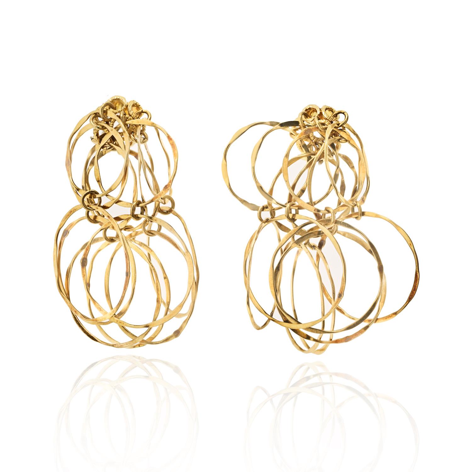 Cartier 18K Yellow Gold 1970's Vintage Hammered Cascade Earrings.
Comprised of cascading tiers of hammered hoops. Connected via round jump rings. Completed by posts with hinged omega backs. Measures: 2 x 2 1/8 inches. 