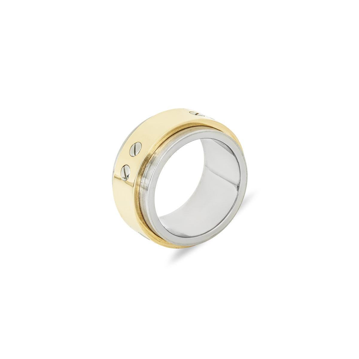 A stainless steel and 18k yellow gold ring from Cartier's Santos collection. This ring features a 12mm wide band crafted from brushed stainless steel, featuring a polished 18k yellow gold inner band. The design is accented with 8 of the collection's