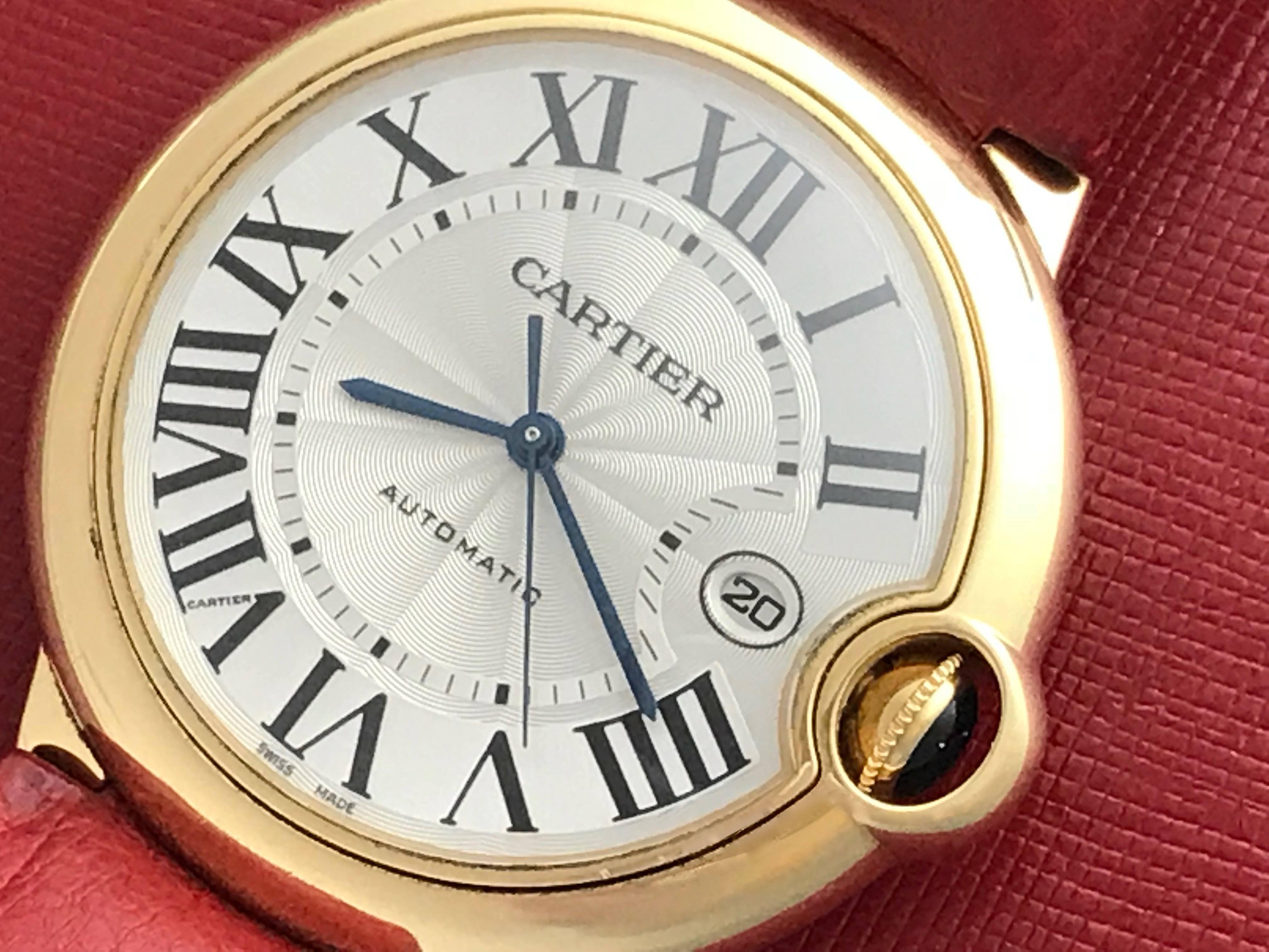 Cartier 18k Yellow Gold Ballon Bleu Automatic Men's Wrist Watch. Model W6900551. Silvered guilloche Dial with black Roman numerals, large 18k Yellow Gold round style case (42mm). Red ostrich strap with 18k Yellow Gold Cartier deployant clasp.