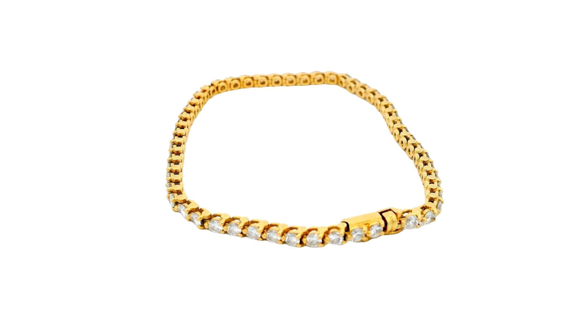 An 18k yellow gold diamond line bracelet by Cartier. The bracelet features 53 round brilliant cut diamonds each individually set in a 3 claw setting with an approximate total weight of 3.71 ct. The bracelet features a box clasp with a length of 6.30