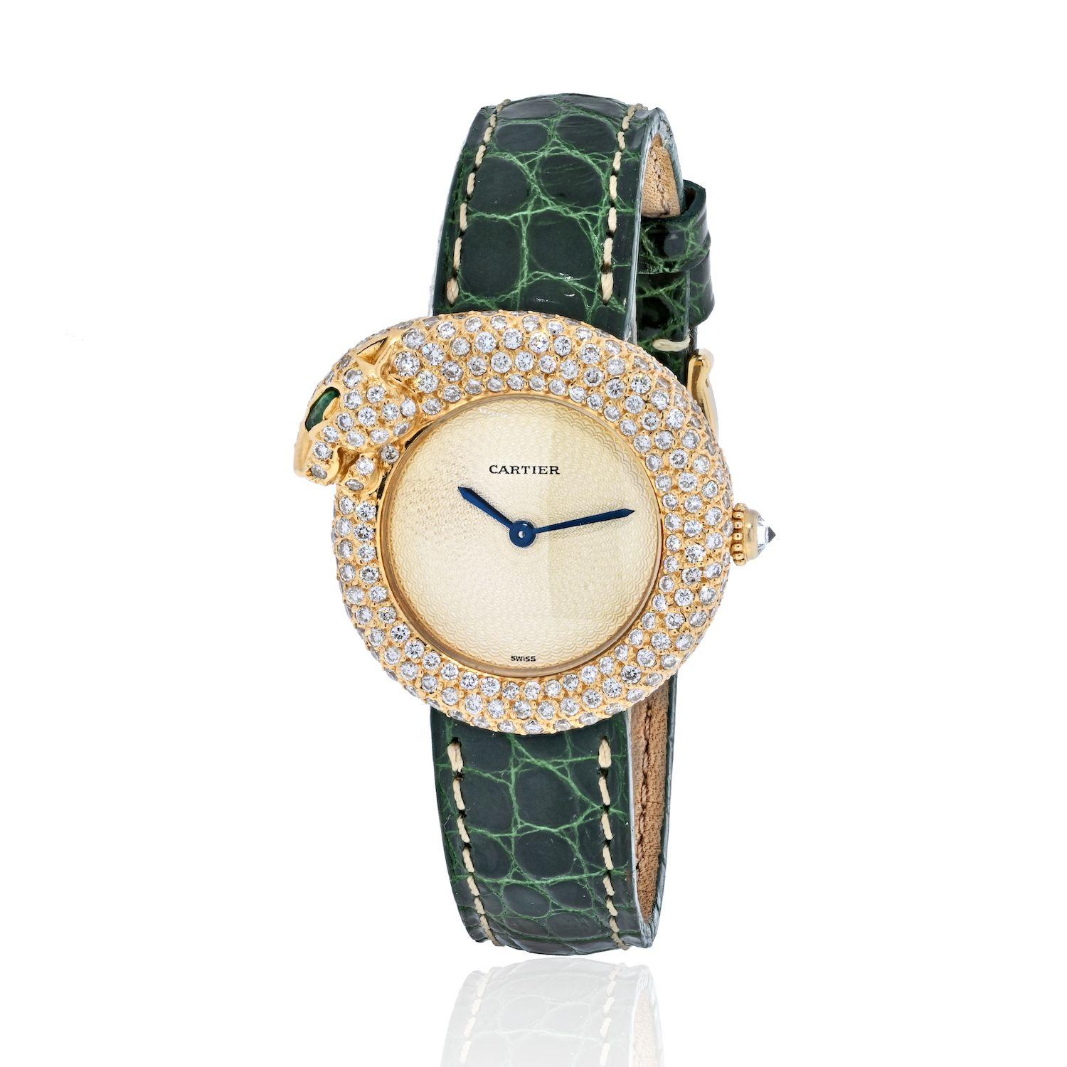 Lady's 18kt yellow gold and diamond Cartier Panthere wristwatch. Two-part case in 18kt yellow gold featuring a emerald-eyed panther forming a bezel, pave-set with approximately 3.00 carats total weight of round brilliant cut diamonds. Off-white