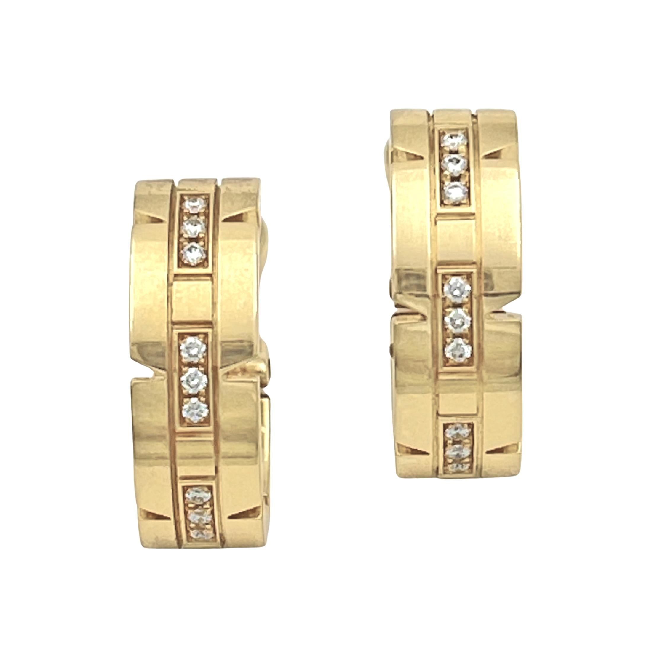 Cartier Tank Francaise hinged hoop earrings in 18k yellow gold, each with a central section accented by thirteen round brilliant-cut diamonds.  Twenty-six diamonds weighing approximately 0.52 total carats (E-F color, VVS1-VVS2 clarity). Pierced