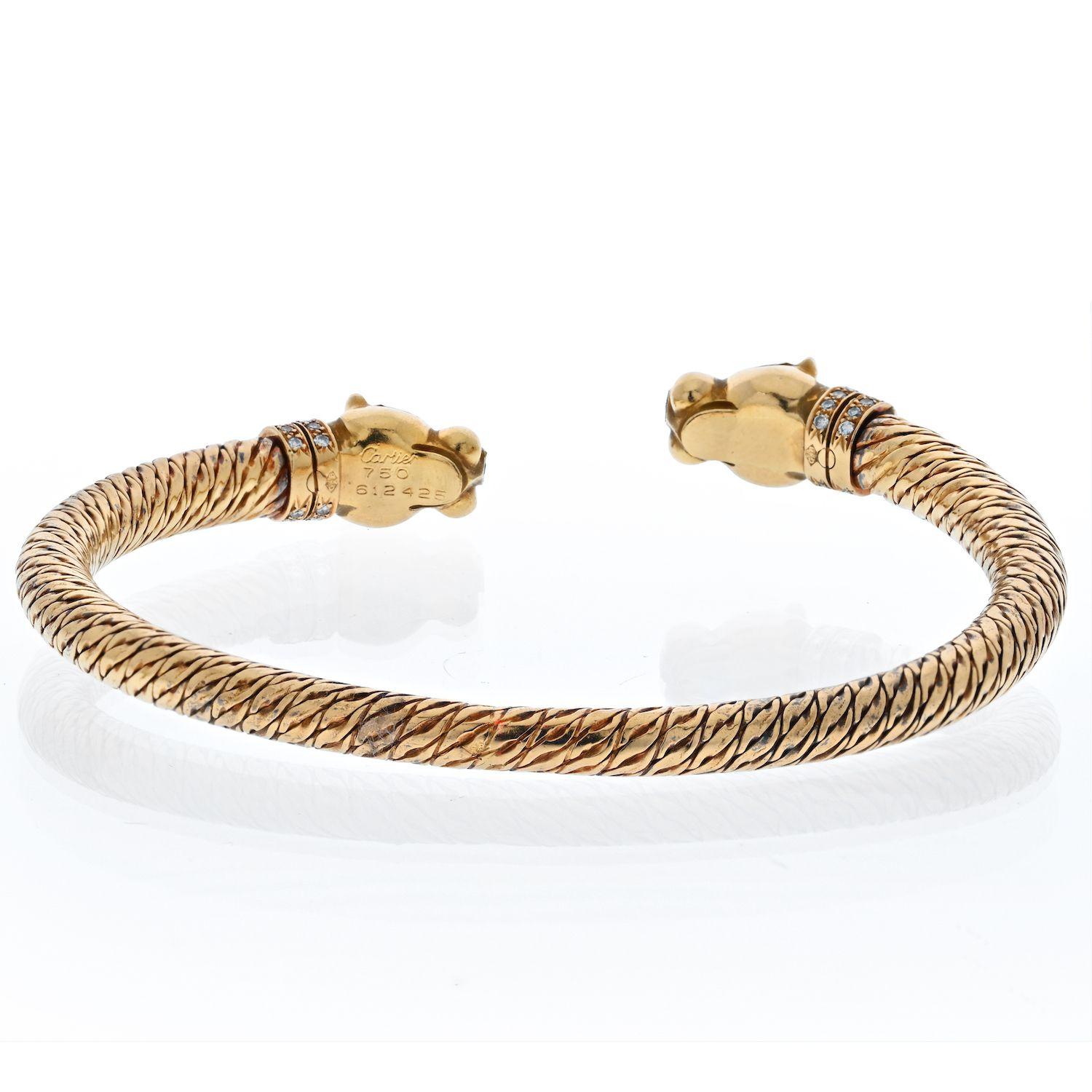 Cartier double headed panthere bangle bracelet made in 18k yellow textured gold. Panther eyes are set with marquise-cut blue sapphires and noses made of black onyx. This series of Cartier Panthere has been discontinued for over 20 years, making this