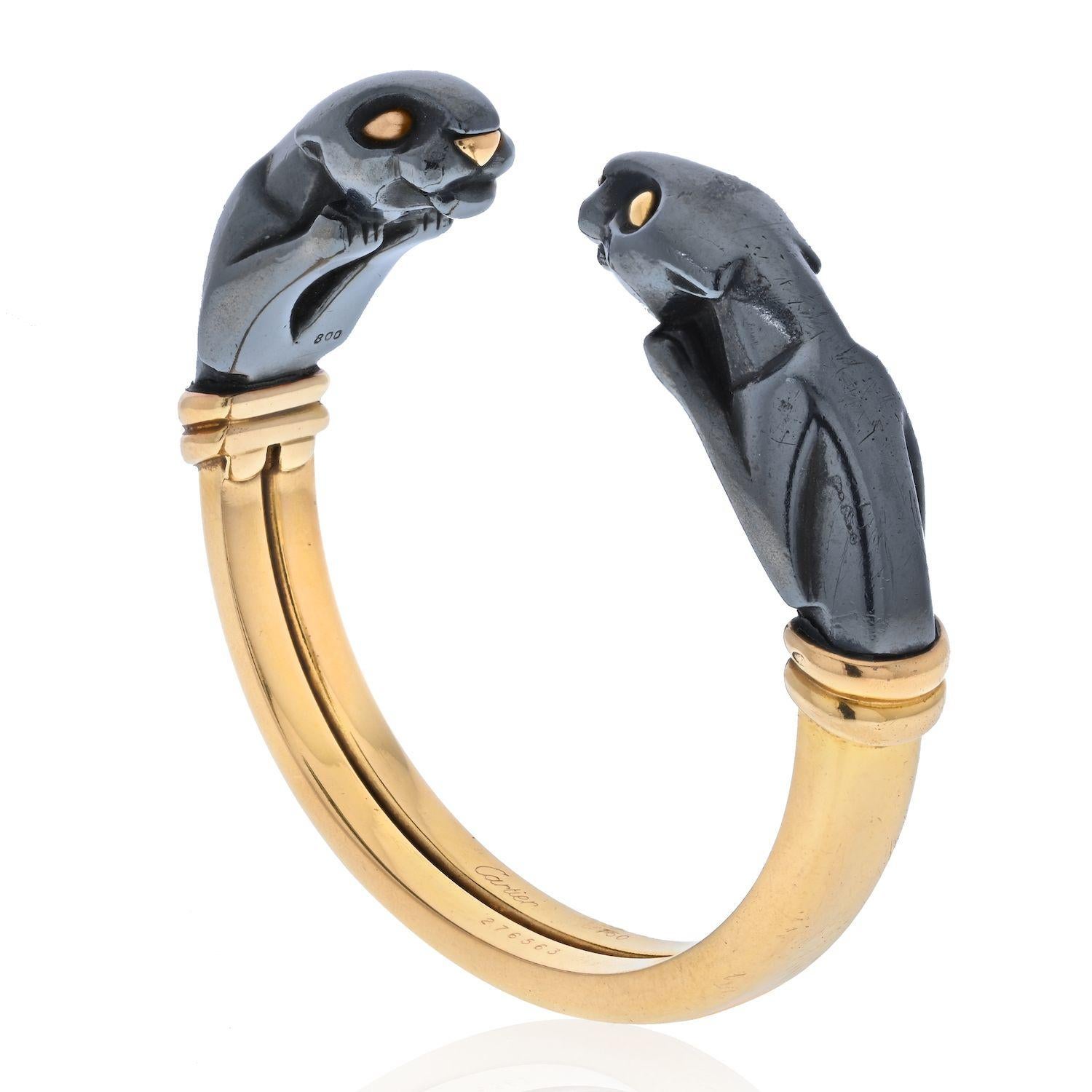 An 18k yellow gold and hematite cuff bracelet from the Panthere de Cartier collection. The bracelet is composed of 2 hematite Panther heads facing each other, joined together by the polished yellow gold cuff. The bracelet would fit a wrist size of