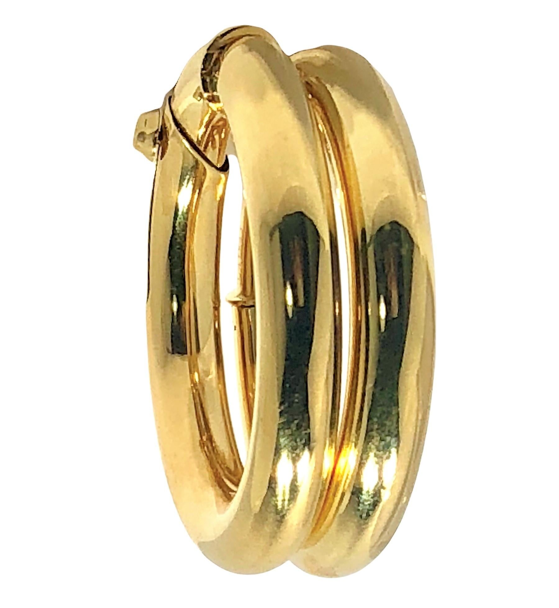 This very large pair of Cartier 18k yellow gold hoop earrings are perfect for ladies with or without pierced ears. Designed with a  clever tension system, they adhere to the ear both securely and comfortably and with no need for a post.  The hollow