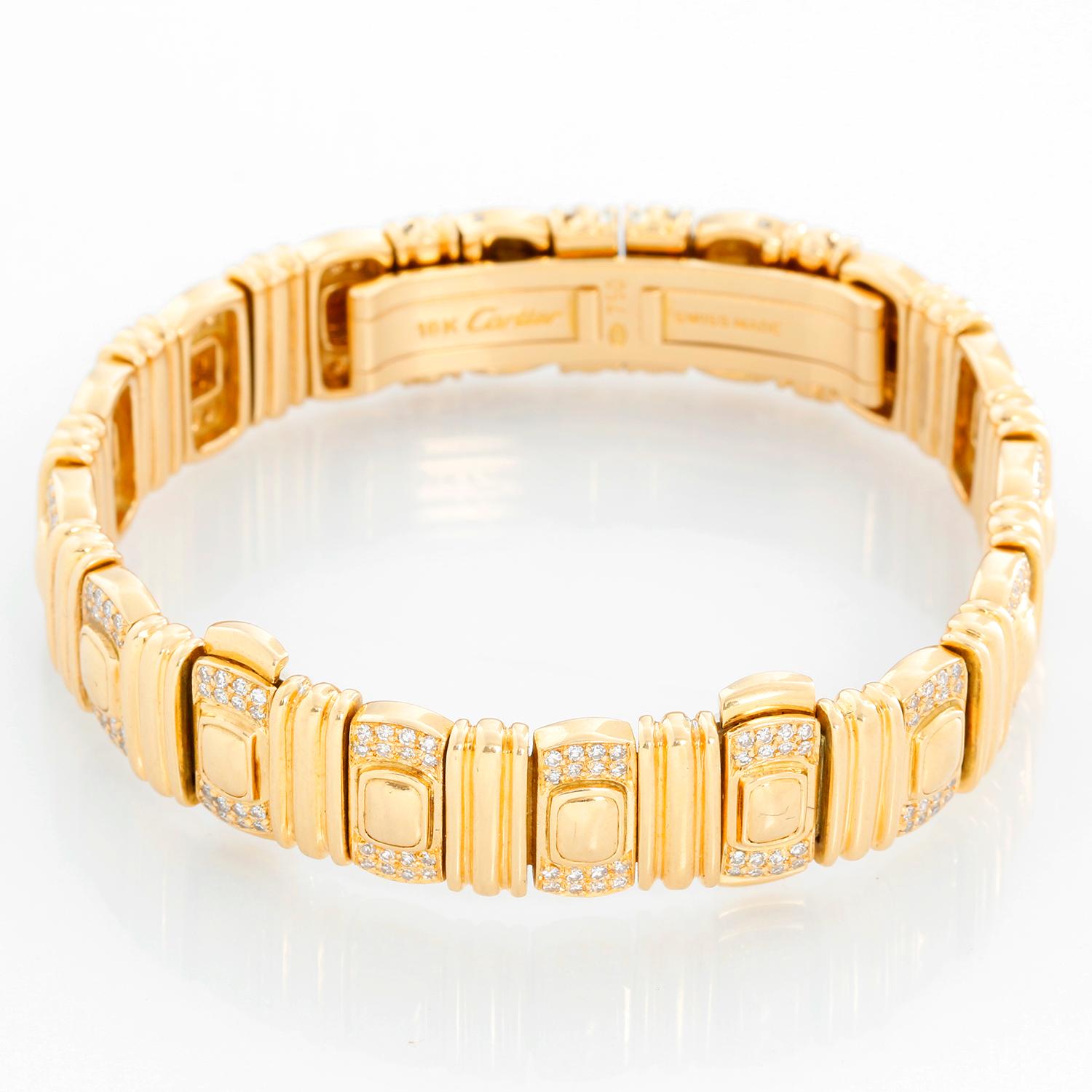 Cartier 18K Yellow gold Quartz Ellipse Ladies Watch / Bracelet  - Quartz. 18K Yellow gold with 3 row of diamonds ( 22 x 26 mm). Ivory dial with Roman numerals. 18K Yellow gold bracelet with diamonds; will fit a 6 3/4 inch wrist. Pre-owed with