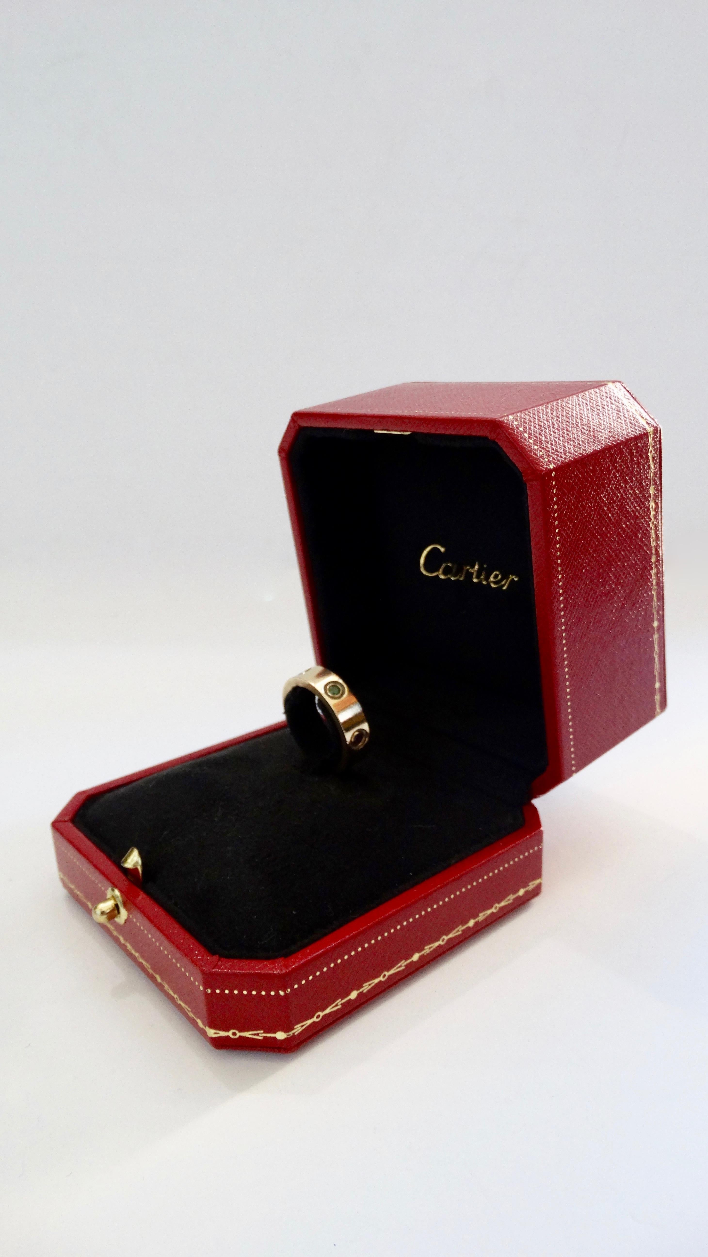 Fall in love with this Cartier Love Ring! Originally launching the Love collection in the 1970s, this ring is from the 2000s and is crafted from 18k Yellow Gold and set with a single pink, blue, and yellow sapphire, one green garnet, one orange