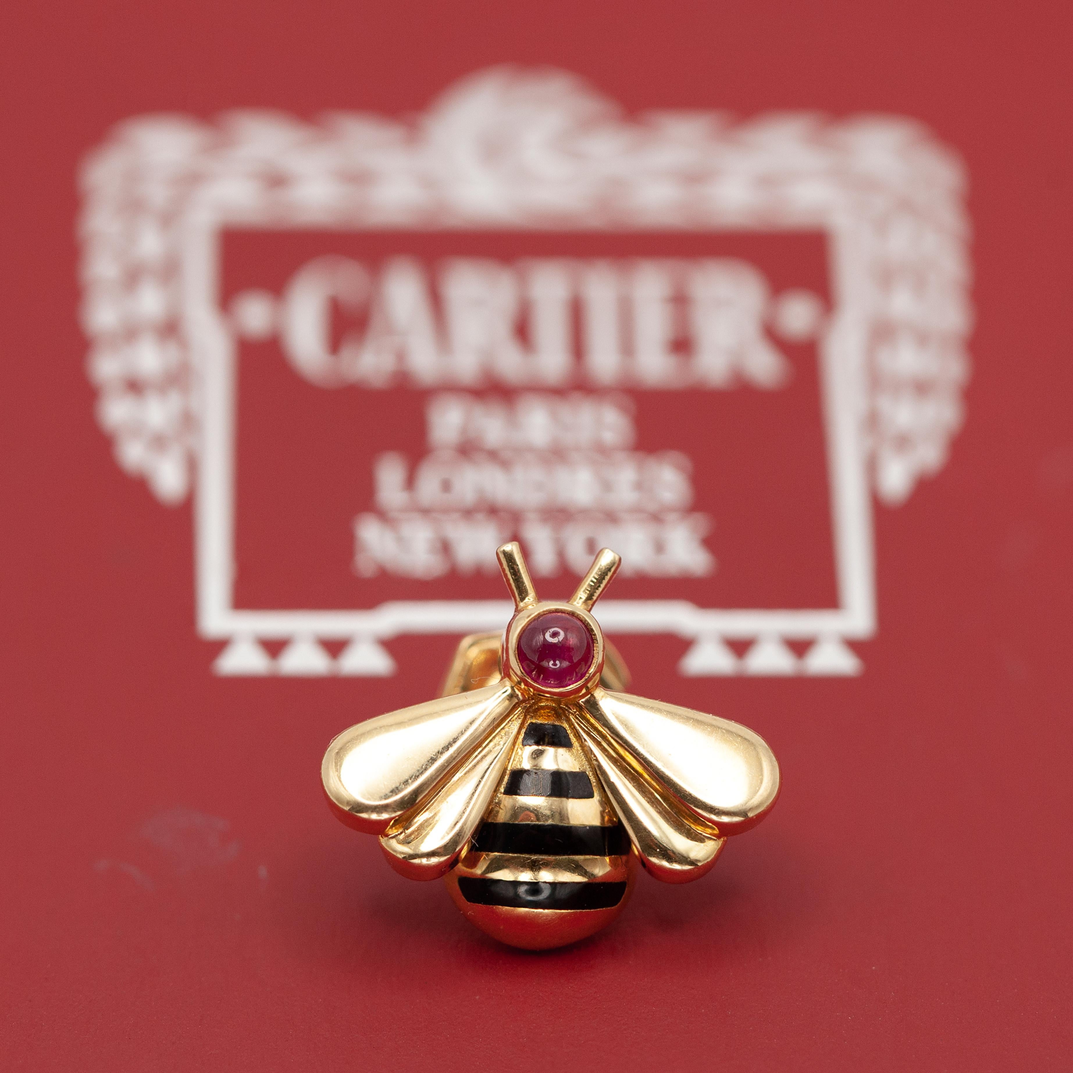Questa spilla a forma di bombo di Cartier è uno squisito esempio di alta artigianalità, realizzata in oro giallo 18 carati. Progettato con eleganza e charme grazie a un rubino cabochon incastonato nella testa e a un busto a strisce di smalto nero.