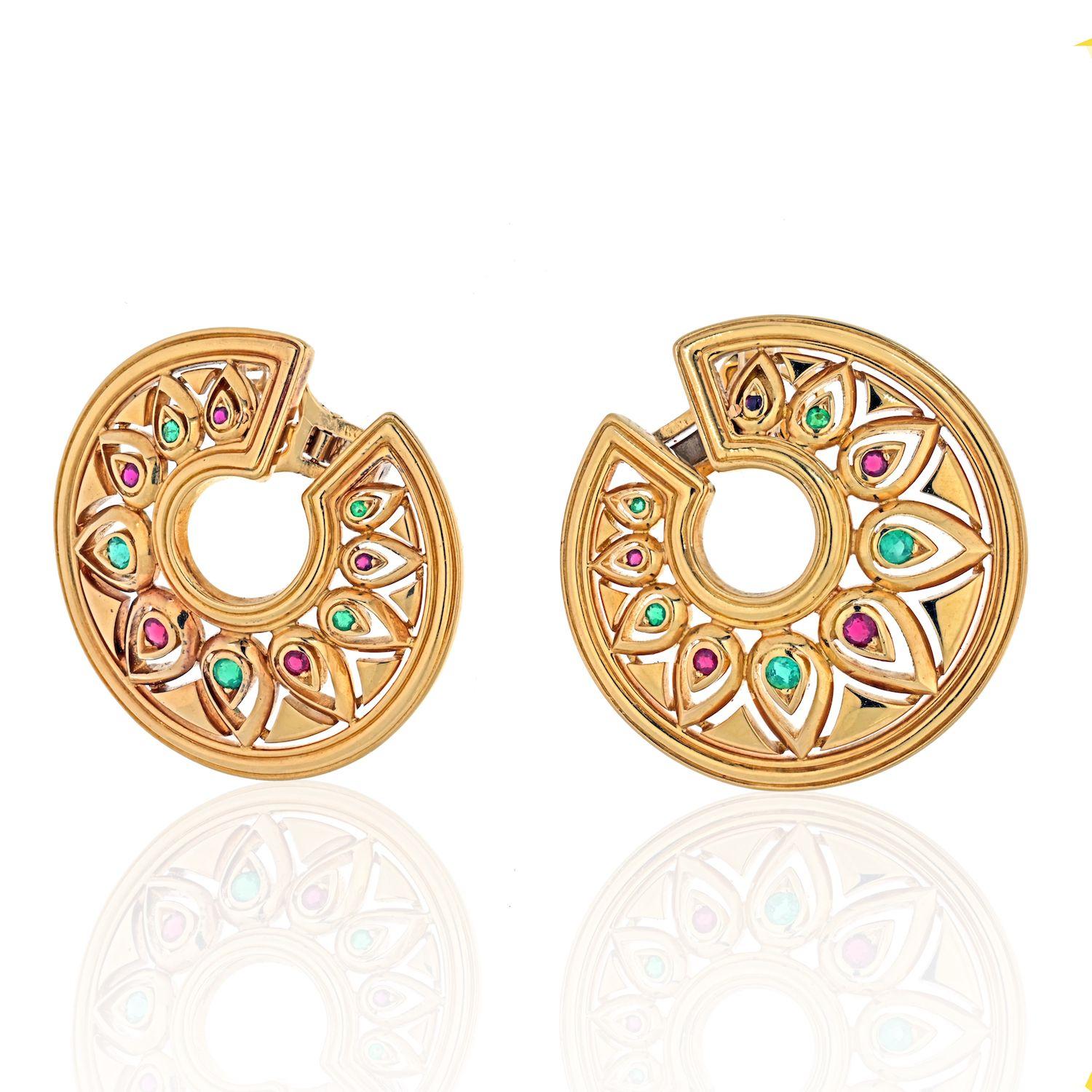 Beautiful and oh so special these Cartier ear-clips are from the 1970-1980's era. Each of round outline with stylized pear shapes in open work design set with green emeralds and rubies. 
Earrings are for pierced ears. 
Each earring measures: 40mm