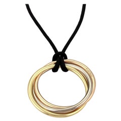 Cartier: Drei Ringe auf schwarzer Seidenhalskette, Cartier 18kt Weiß-, Gelb- und Roségold