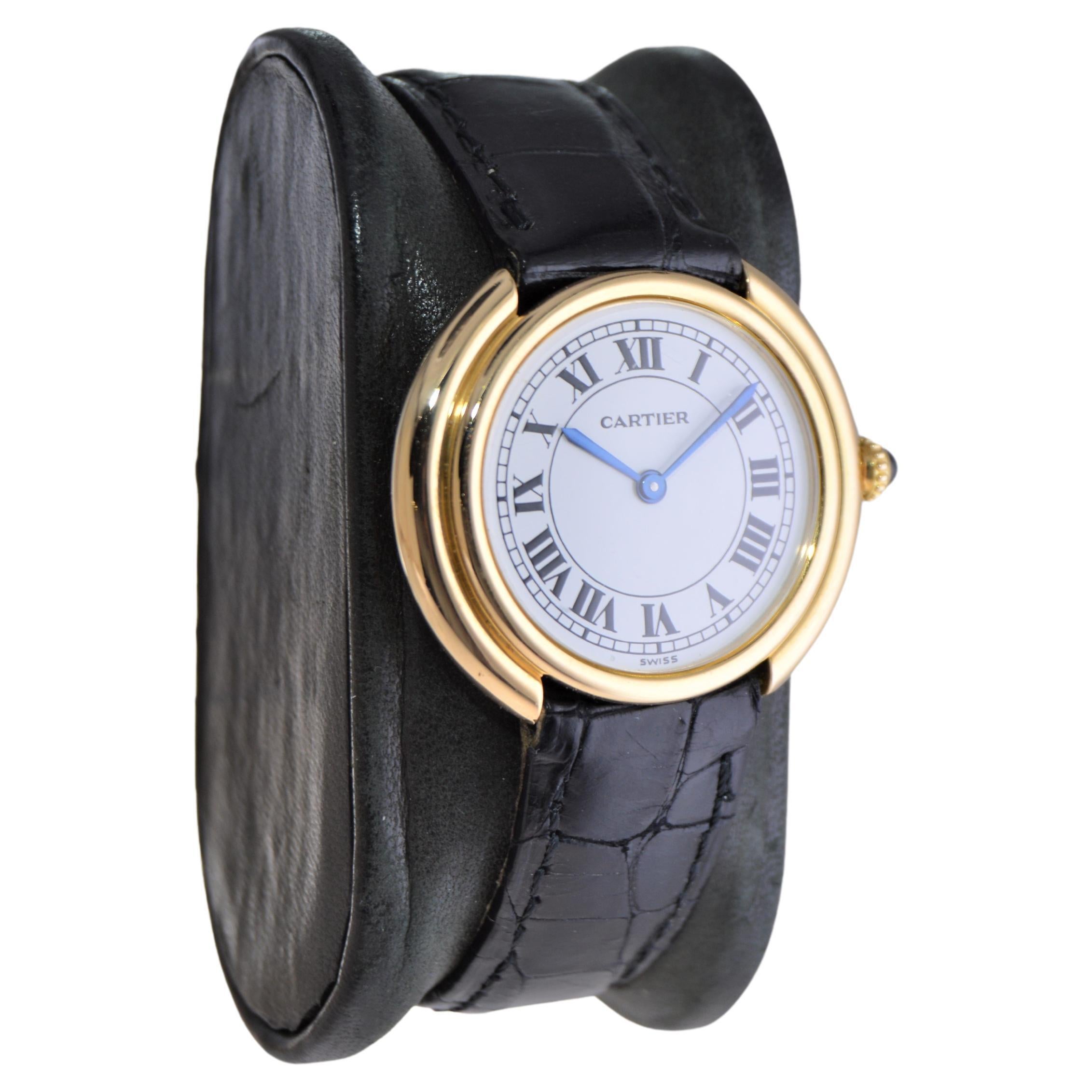 FACTORY / HOUSE: Cartier
STYLE / REFERENCE: Round Art Deco 
METAL / MATERIAL: 18Kt. Yellow Gold
CIRCA / YEAR: 1970's
DIMENSIONS / SIZE: Length 32mm X Diameter 28mm
MOVEMENT / CALIBER: Manual Winding / 17 Jewels 
DIAL / HANDS: Original White with