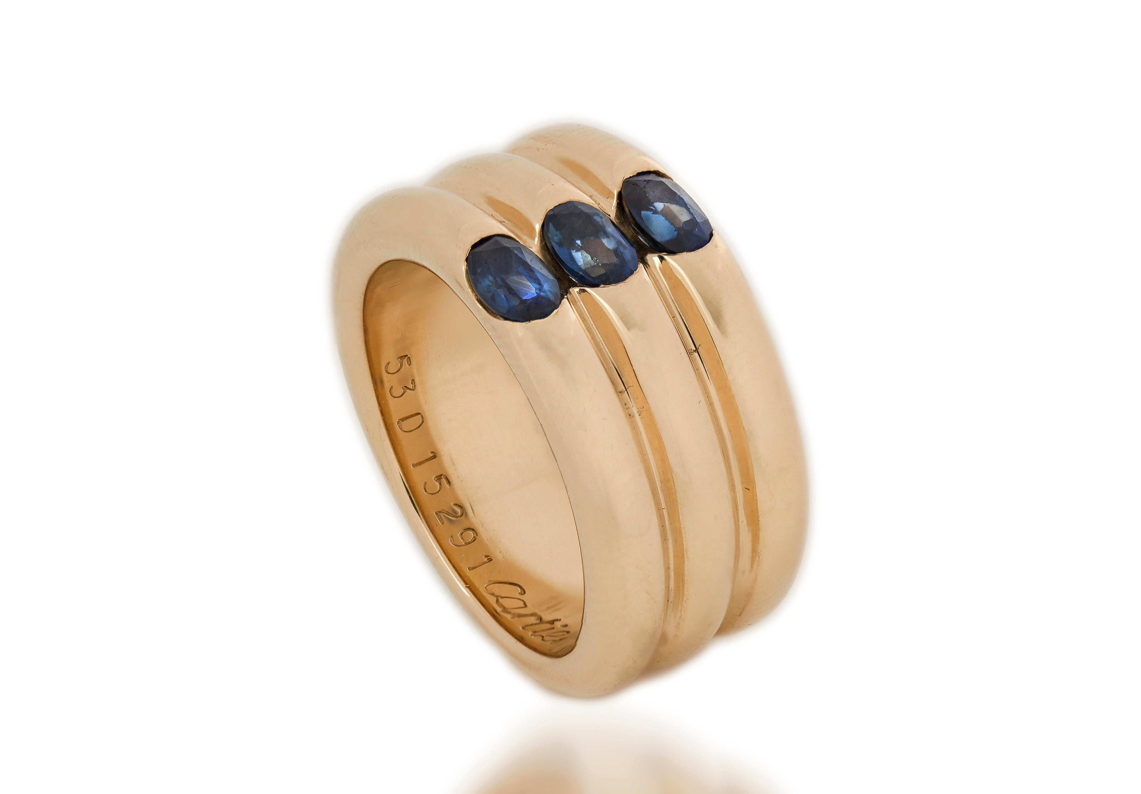 Cartier 18kt yellow gold triple ring band with blue sapphires.
Made in France, Paris 1995
Fully hallmarked and signed Cartier and serial number.

Dimension -
Diameter x Width : 2.3 x 1 cm
Finger Size : (UK) = N (US) = 7 (EU) = 53
Weight : 19