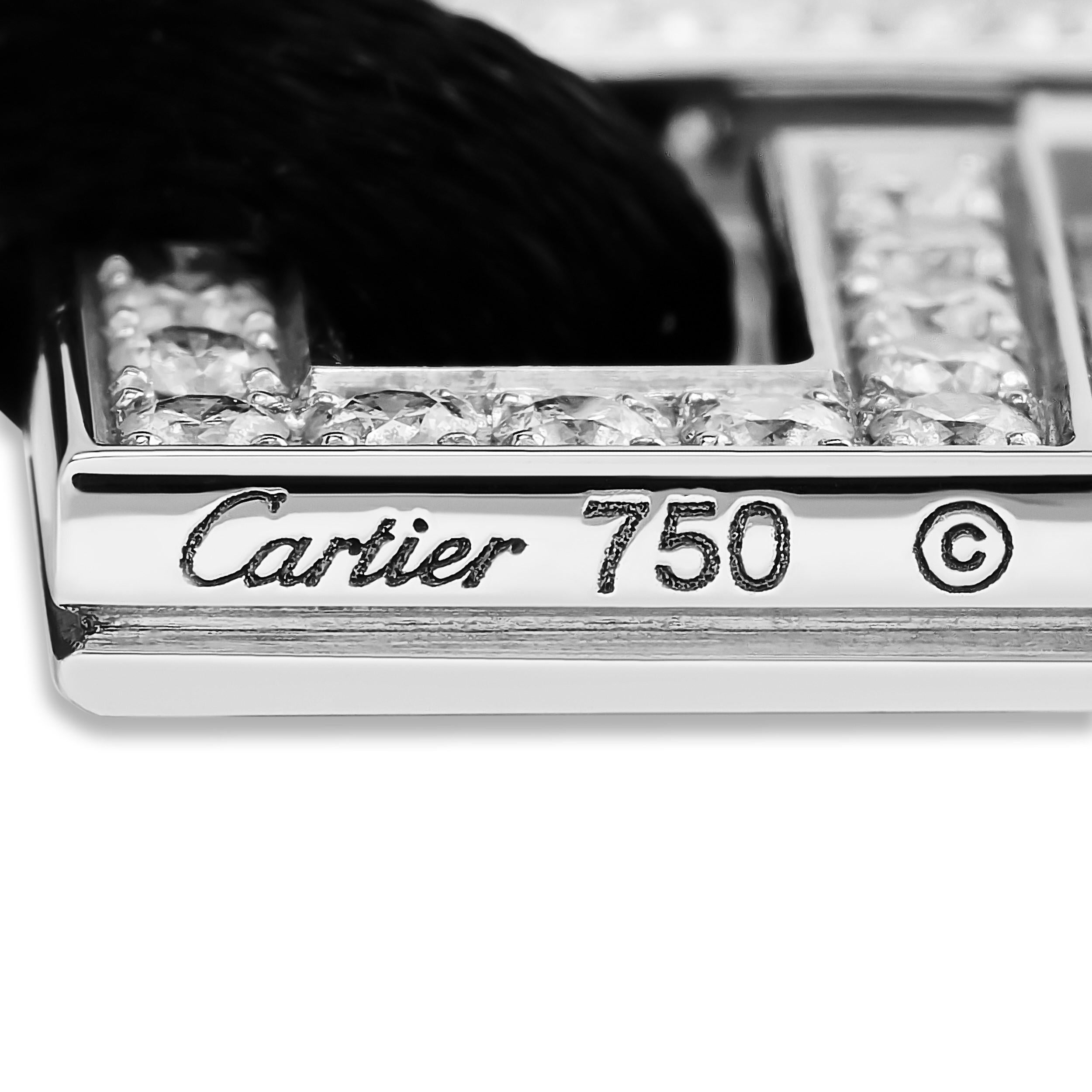 Este cautivador colgante Cartier presenta un motivo de Dragón Du elaborado en oro blanco de 18 quilates, que simboliza el poder y la sabiduría. El colgante está suspendido de un cordón negro, creando un contraste llamativo y elegante.
Este collar