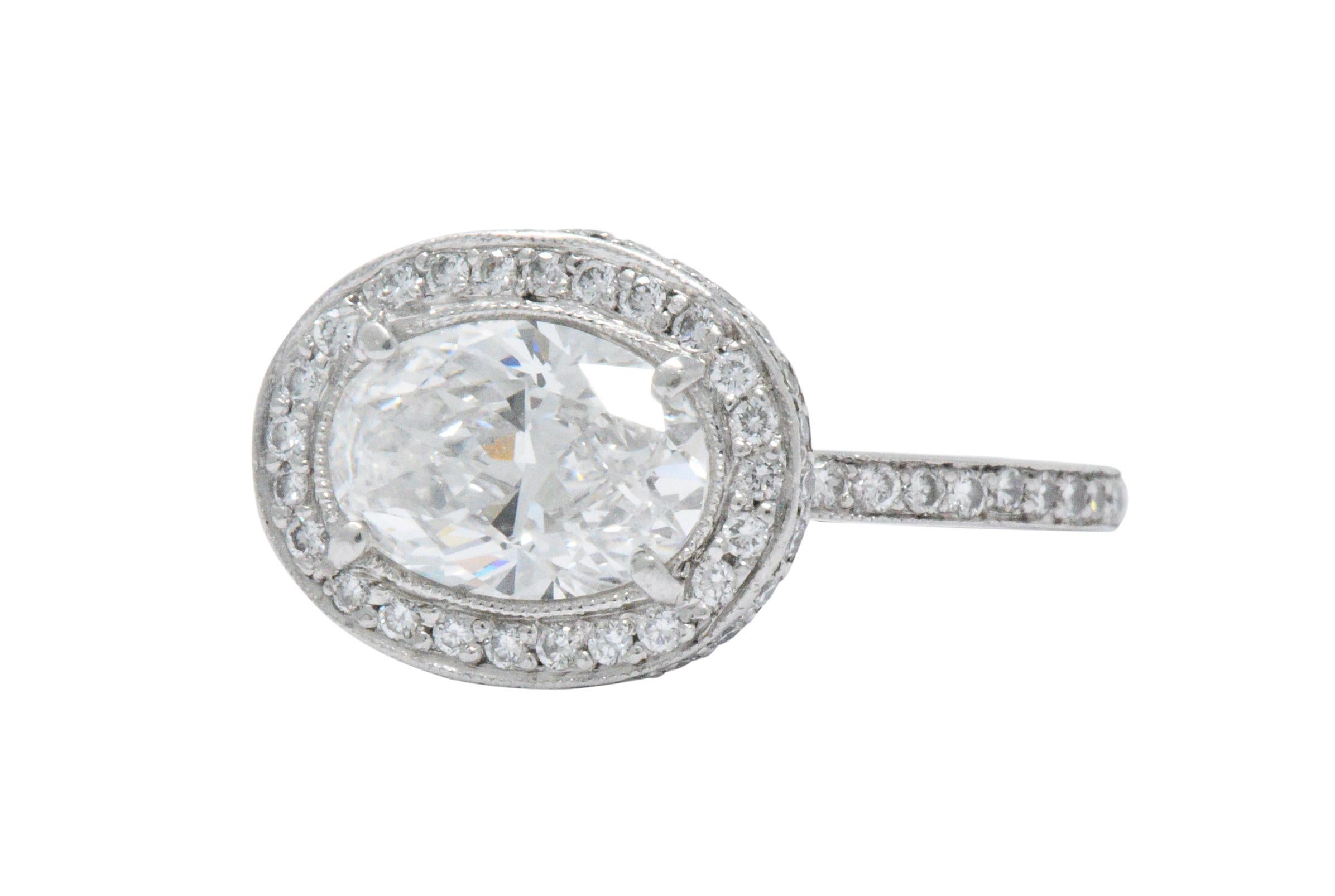 Centering an oval cut diamond weighing 1.41 carats, E color and VS2 clarity

Diamond accents on top, amidst the sides, under the head and along the shank, approximately 0.55 carats total, G/H color and VS to SI clarity

Top of the ring measures 10.4