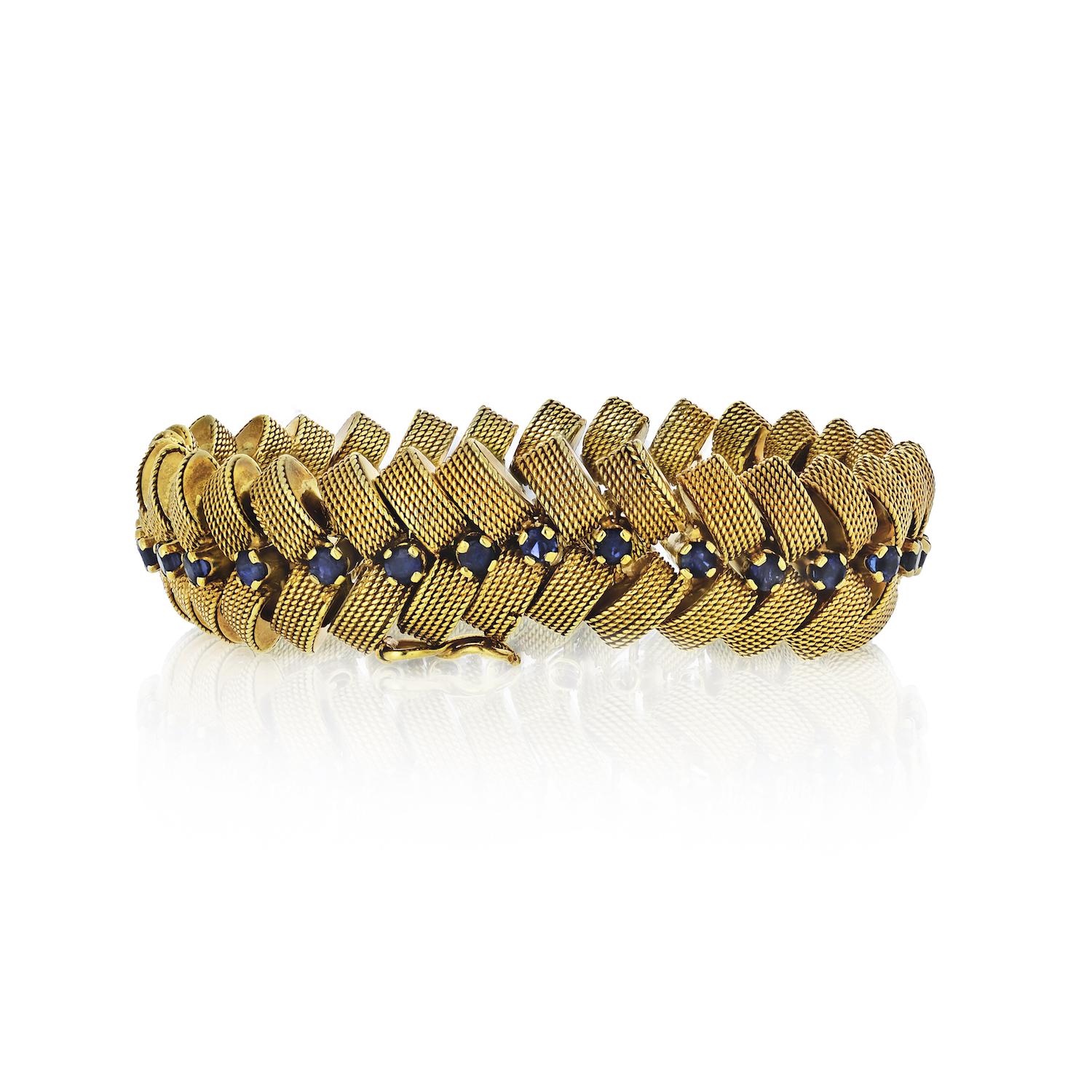 Very rare this Cartier yellow gold bracelet in braid-like design, set with round cut sapphires will become your favorite vintage piece. There are 32 sapphires of a royal blue color running down the center. Each sapphire is about 3mm wide. Box lock