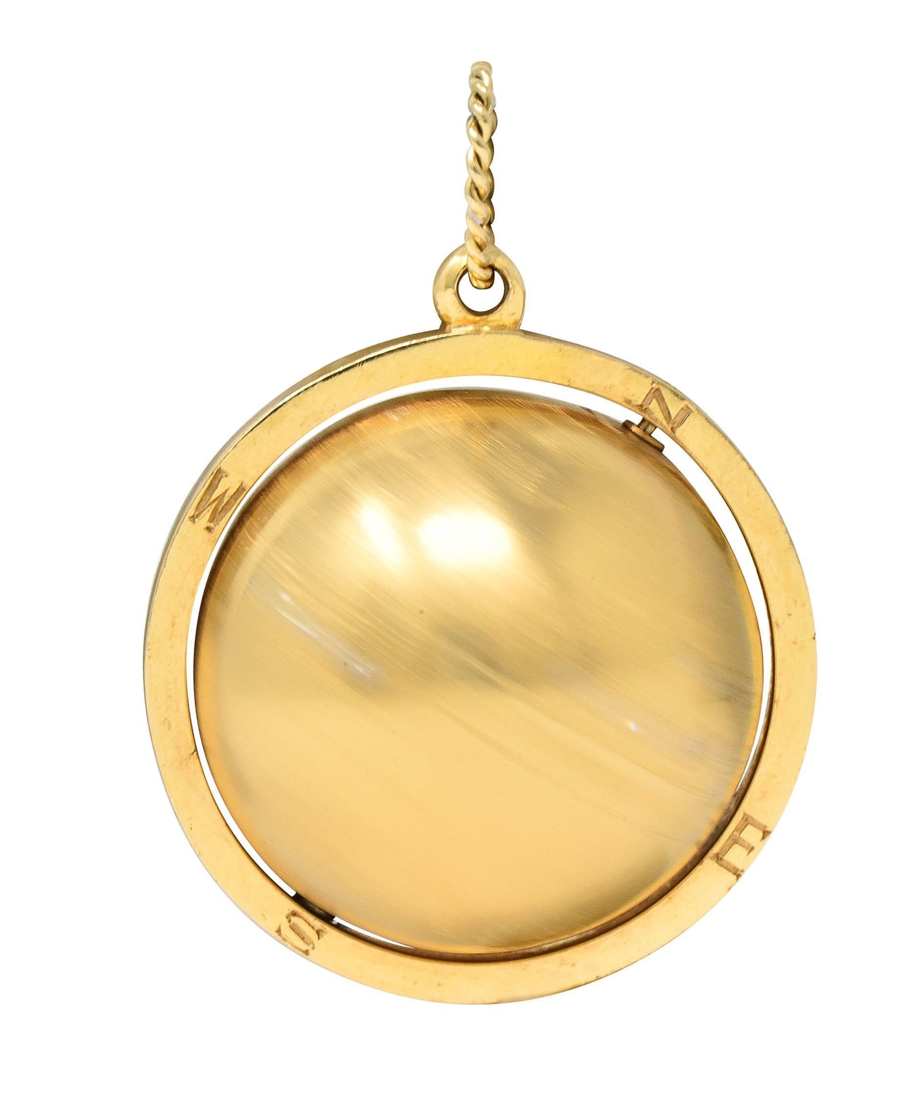 Designed as a gold sphere engraved as a world globe that spins on an axis 
Engraved with continent names and boundaries with textured oceans
Accented by flush set round brilliant cut diamonds at major cities
Weighing approximately 0.25 carat total -
