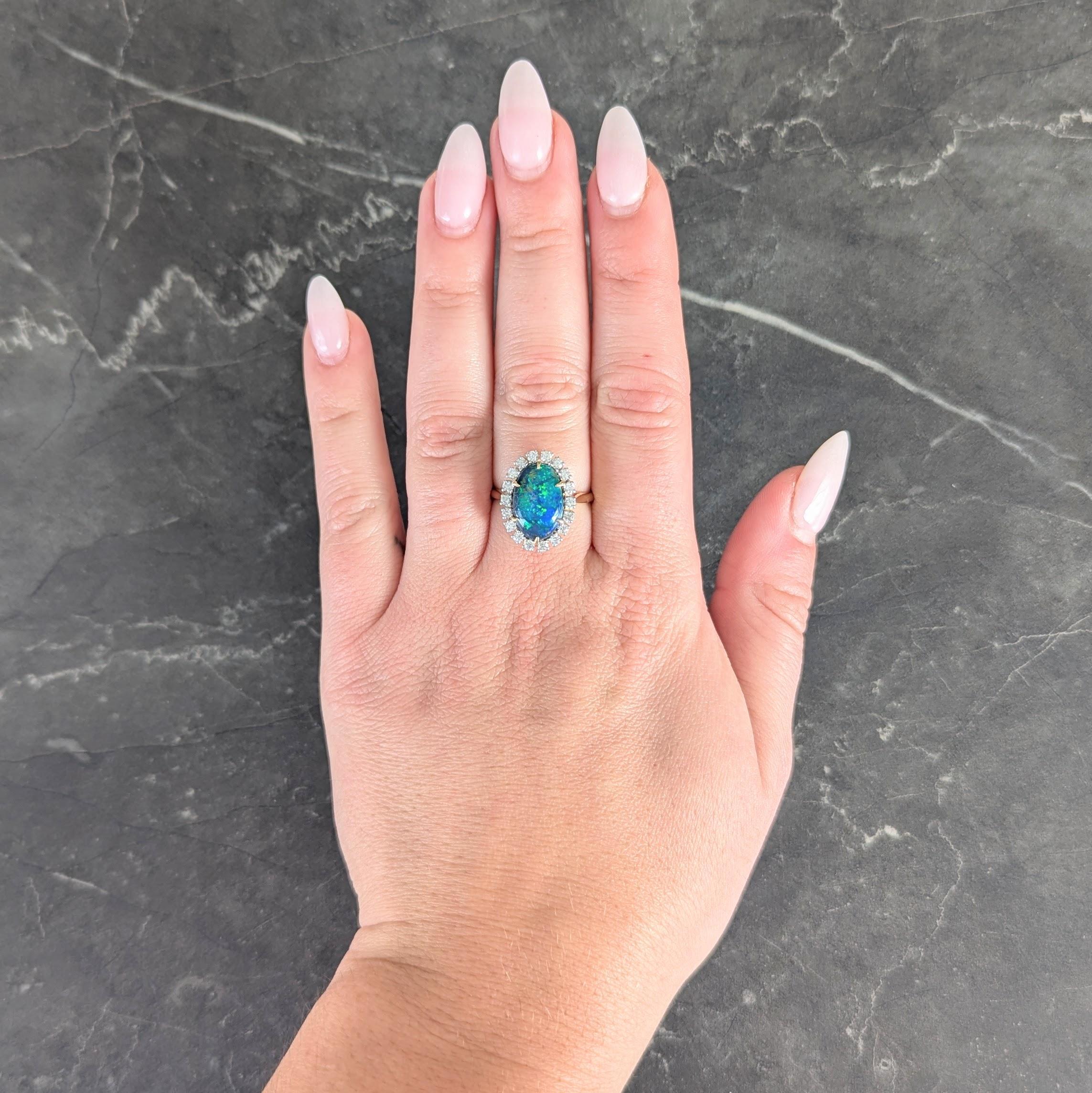 Centering an oval cut opal cabochon measuring 8.75 x 13.5 mm
Black in body color with strong blue/green play-of-color
Set with yellow gold talon prongs with halo surround
Comprised of round brilliant cut diamonds
Weighing approximately 0.54 carats
