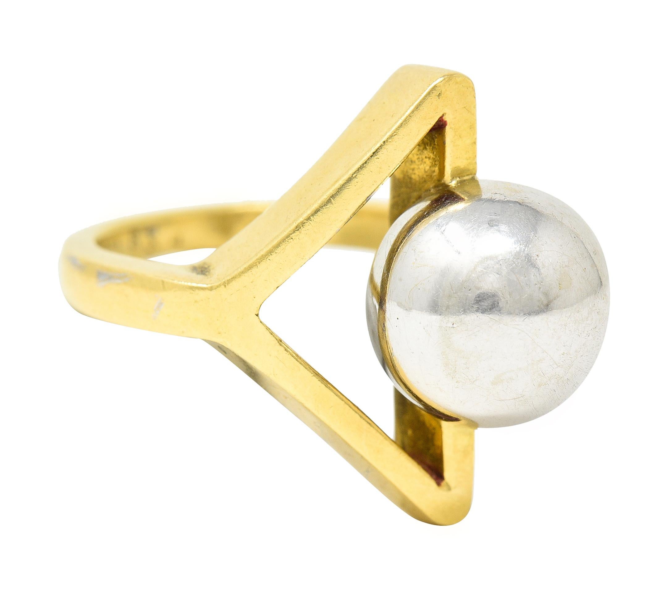 Featuring a 10.0 mm round white gold sphere - metallic gray. Bisecting a pierced triangle shape with point continuing into shank. Stamped 18kt for 18 karat gold. Numbered and fully signed Cartier, Italy. Circa: 1960's. Ring size: 3 1/4 and sizable.