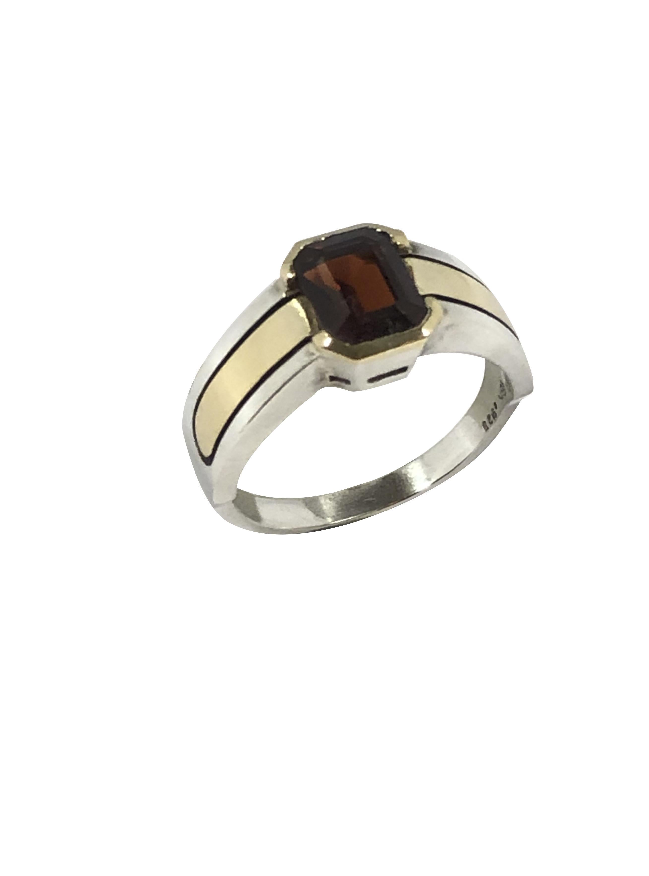 Circa 1970s Cartier 18k Yellow Gold and .925 Sterling Silver Ring, Set with a Fine Color Rectangle step cut Garnet approximately 1.50 Carat, finger size 7. Comes in a Cartier presentation Box. 