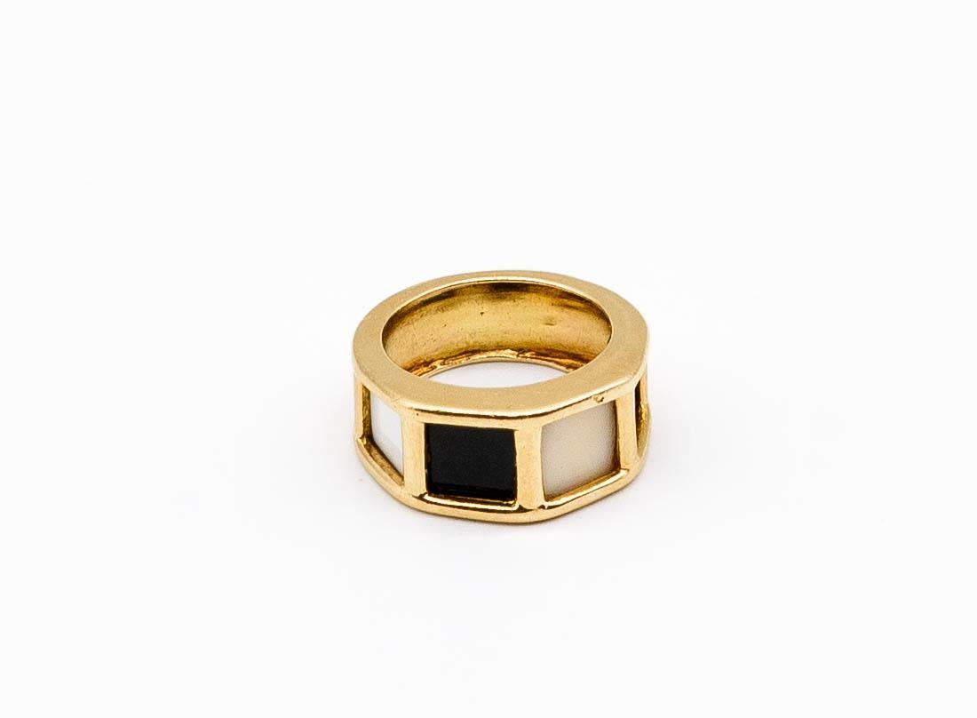 A delightful little tidbit most certainly from the 1970's, this small Cartier ring makes a big statement.   Four simple panels of color - two white, agate, two black onyx - parade across the center of the ring, spanning the wearer's finger evenly. 