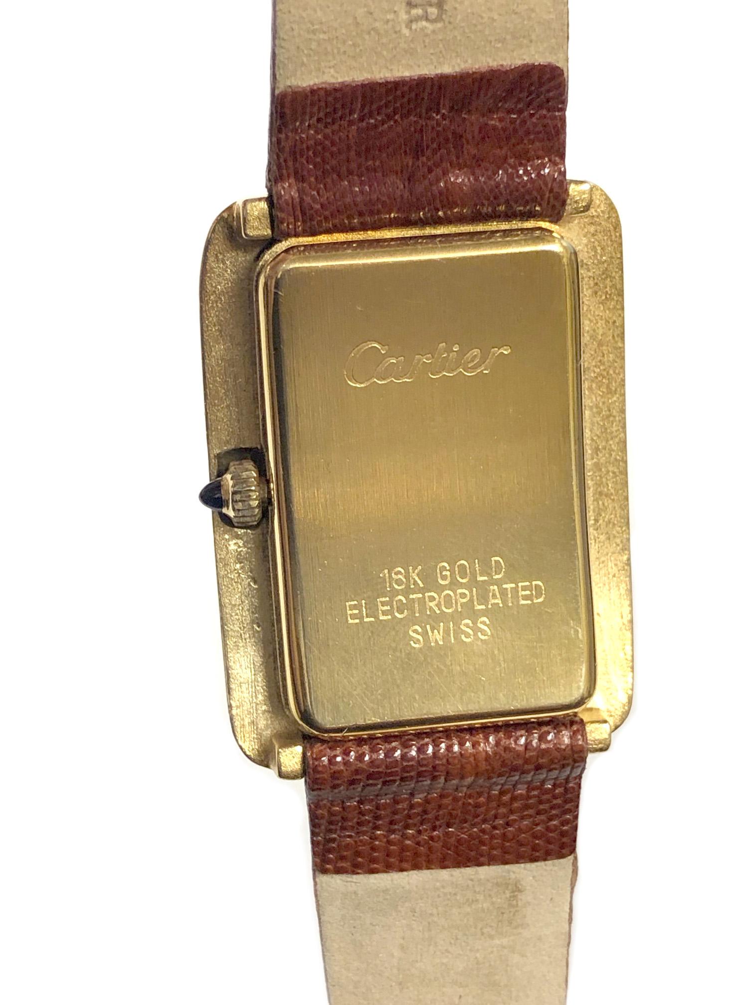 Circa 1970s Cartier Wrist Watch, 37 X 27 MM Yellow Gold Plated Stepped Case, 17 Jewel Mechanical, Manual Wind Movement, Chocolate Brown Dial with Gold Roman Numerals, Sapphire Crown. New Brown Lizard Strap with original Cartier Gold Plate buckle.