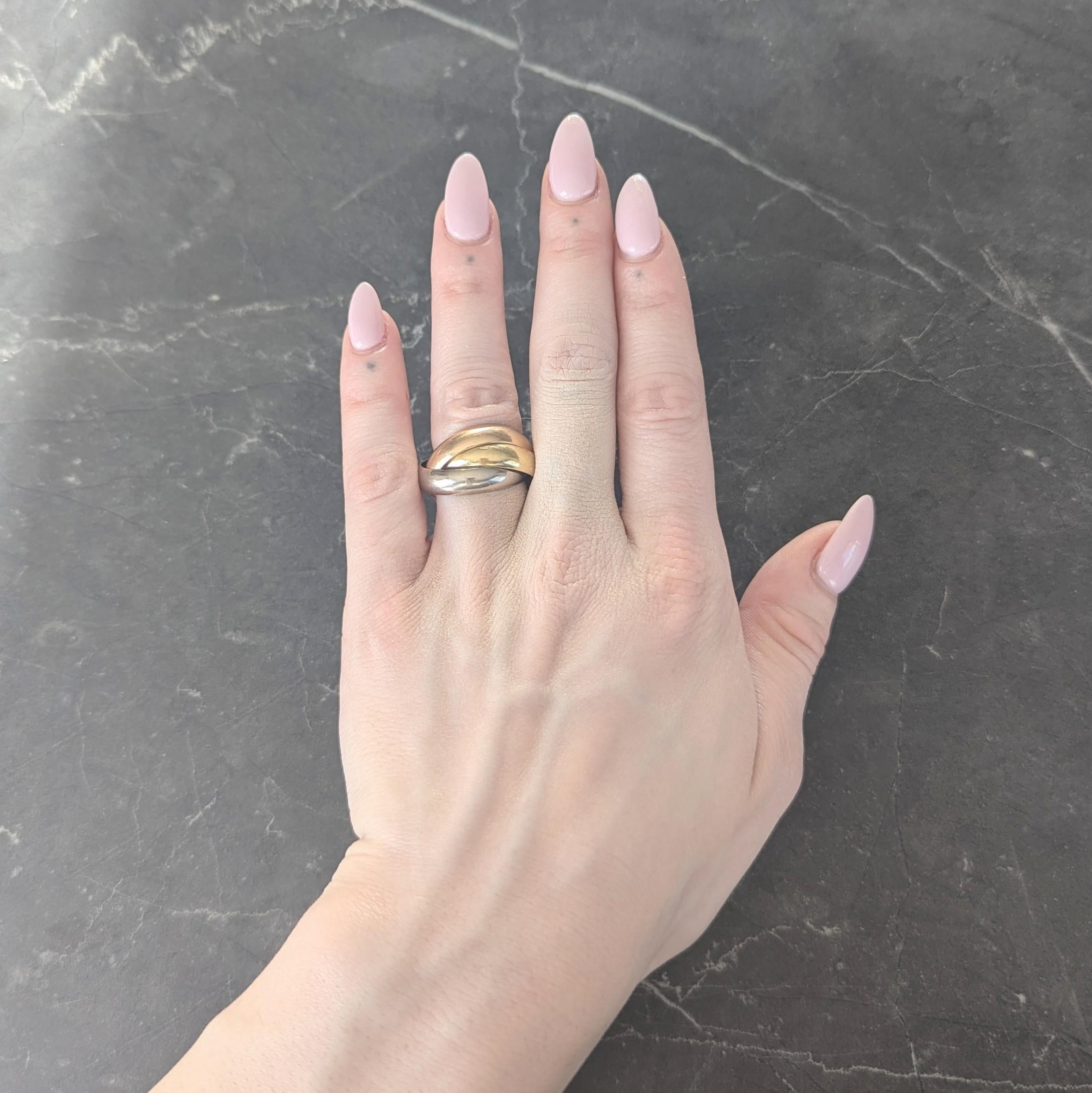 Ring is comprised of three interlocking bands of yellow, rose, and white gold
Slightly curved - rose gold is inscribed 'Cartier'
With high polished finish throughout
Stamped for 18 karat gold
Numbered and fully signed for Cartier
Circa: 1980s
Ring