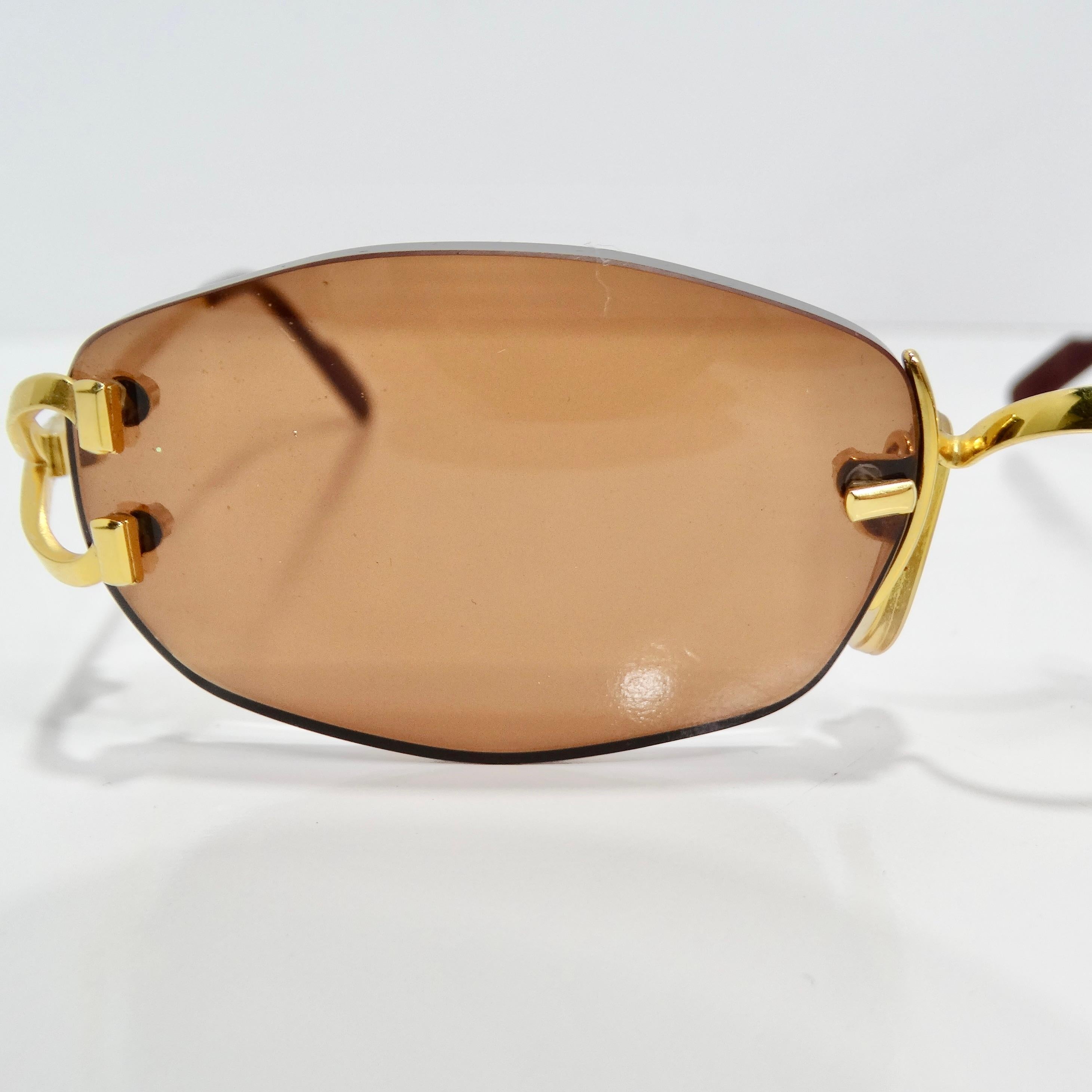 Die Cartier 1990s Gold Tone Capri Sonnenbrille ist ein luxuriöses und zeitloses Accessoire, das Eleganz und Raffinesse ausstrahlt. Diese mit viel Liebe zum Detail gefertigte randlose Sonnenbrille setzt ein markantes Zeichen und bietet gleichzeitig
