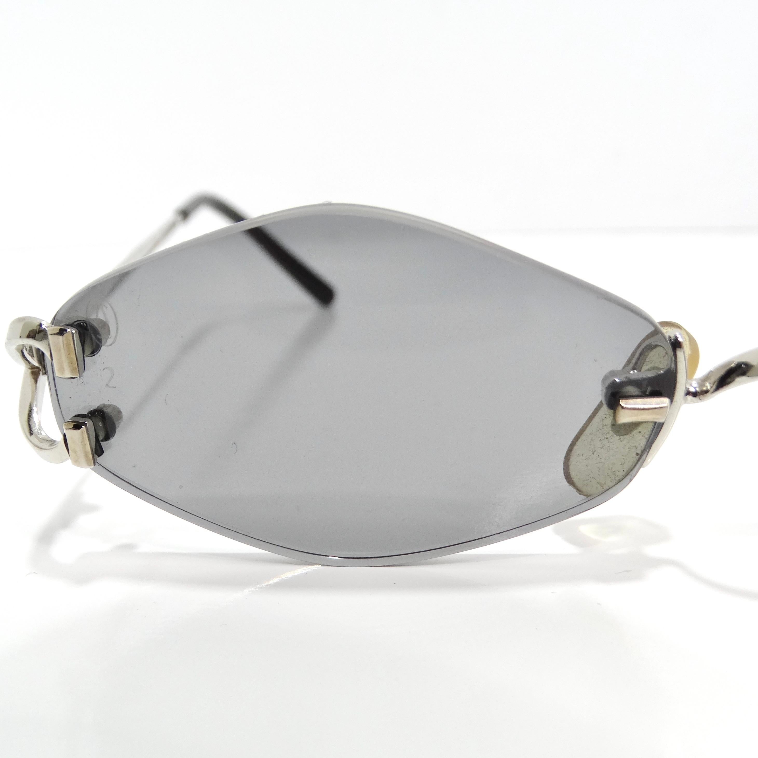 Introducing the Cartier 1990s Silver Tone Rimless Sunglasses, a stunning and luxurious accessory that embodies timeless elegance and sophistication. Meticulously crafted with attention to detail, these rimless sunglasses are designed to make a bold