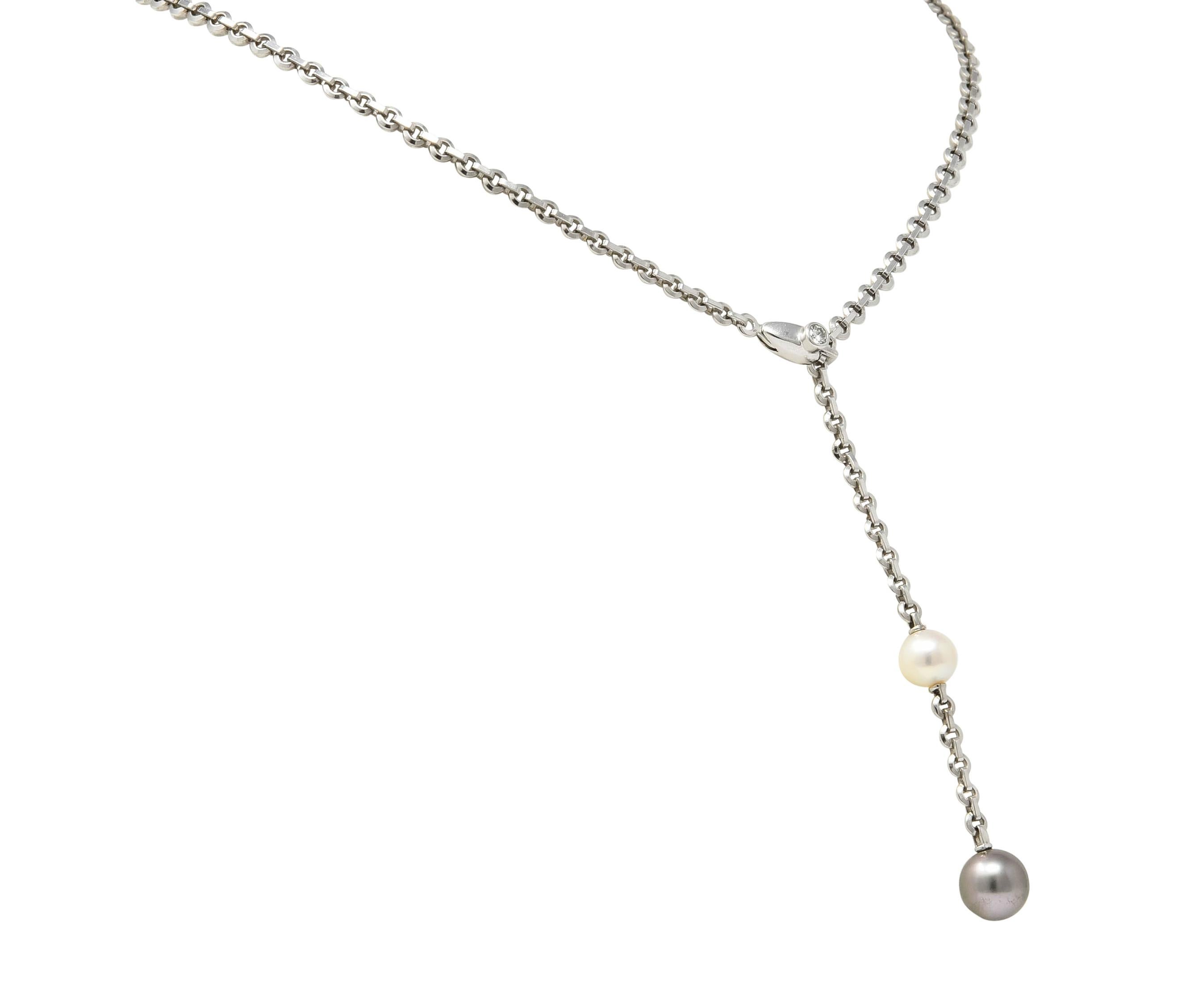 Stylized white gold box chain lariat style necklace terminating on one end in two round cultured pearls measuring approximately 7.3 mm to 8.8 mm

Larger Tahitian pearl is gray in body color with green overtones, smaller pearl is cream in body color