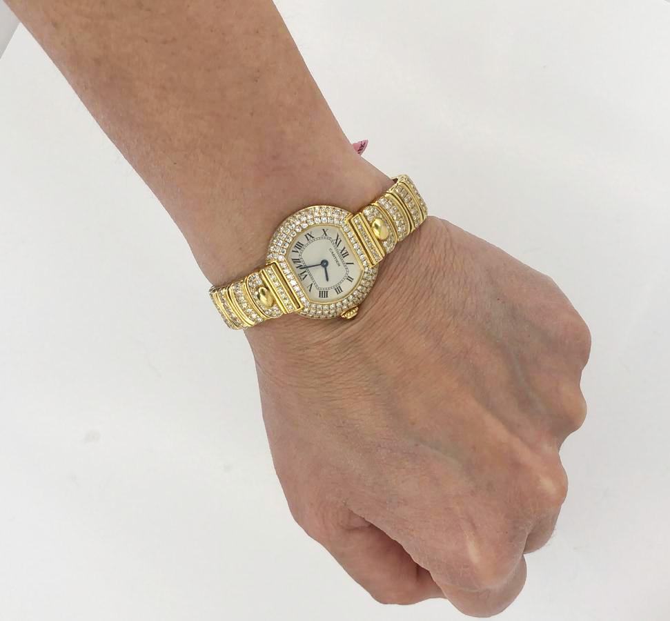Cartier 26mm Diamantuhr in 18k Gelbgold.

Eine klassische Uhr von Cartier im Ost-West-Look - mit einem weiß schimmernden Zifferblatt, umgeben von Reihen weißer, in 18 Karat Gelbgold gefasster Diamanten.

Gewicht der Diamanten insgesamt ca. 5.00