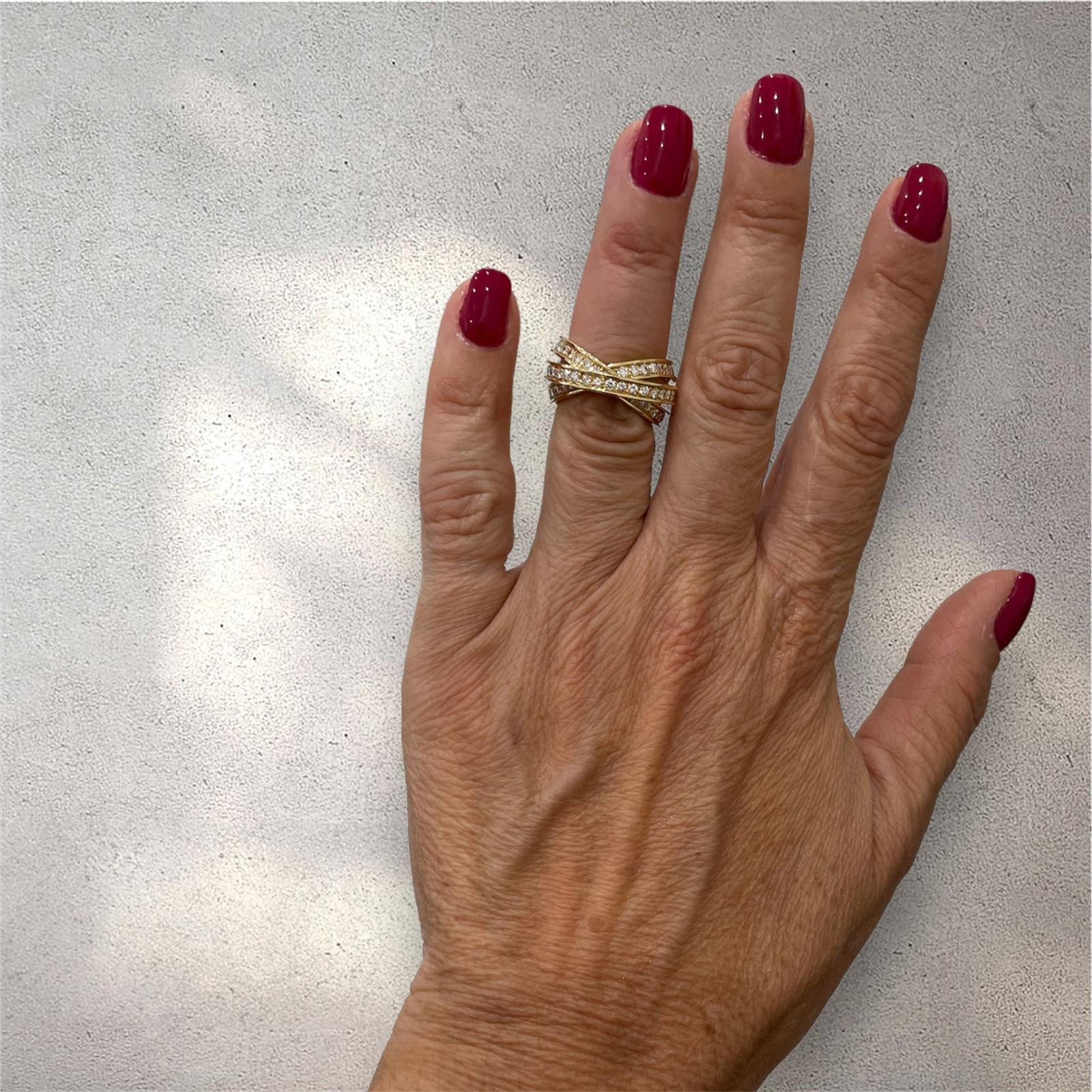 This Cartier Trinity rolling ring features three intertwined 18k yellow gold bands set all the way around with approximately 3 carats of round brilliant cut diamonds, VVS clarity, E/F color. 

CONDITION: Pre-owned - Excellent 
METAL: 18k