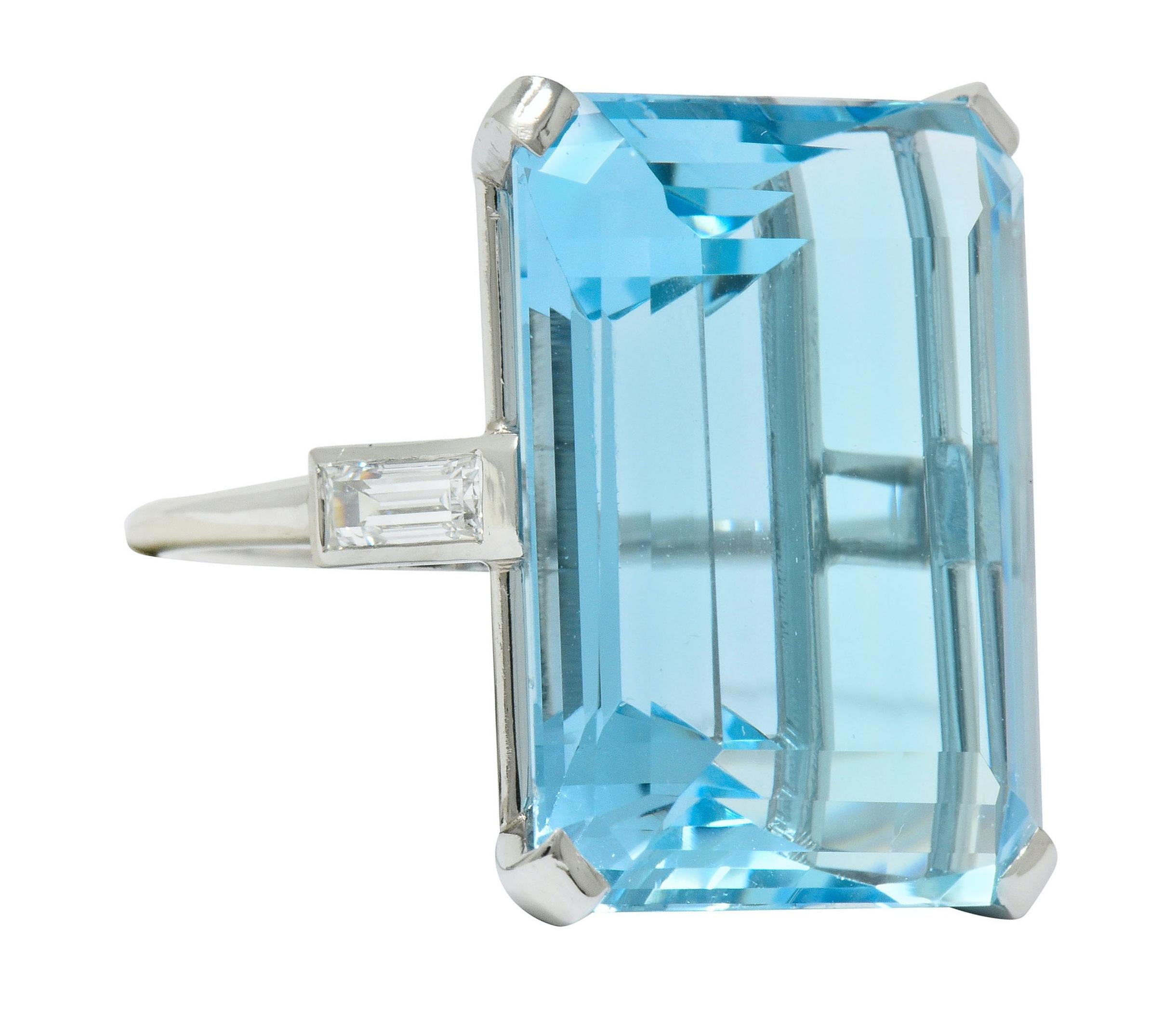 Designed as a cathedral basket style ring centering an emerald cut aquamarine weighing approximately 35.49 carats, transparent and a striking light blue color

Flanked by two baguette cut diamonds, flush set into shoulders, weighing approximately