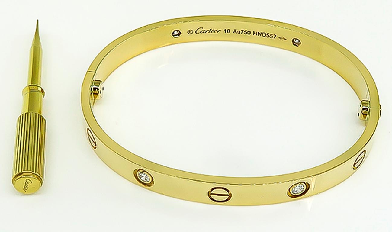 This fabulous 18k yellow gold love bangle by Cartier is set with 4 sparkling round cut diamonds that weigh approximately 0.40ct. The bangle is size 18 and weighs 32.7 grams. 
It is signed Cartier 18 Au750 HND557 and comes with a