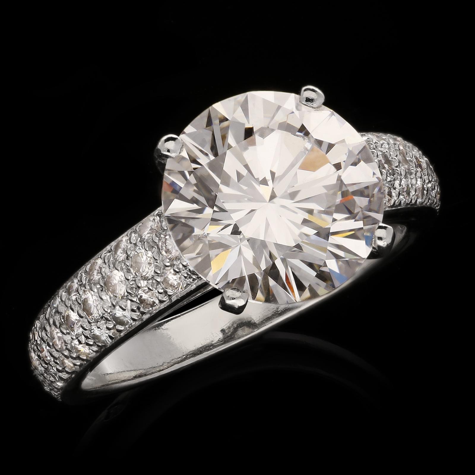 A beautiful solitaire diamond ring by Cartier circa 2000s, set to the centre with a round brilliant diamond weighing 4.17cts and of D colour, VVS2 clarity and Type IIA classification, four claw set in platinum between tapering shoulders pavé set