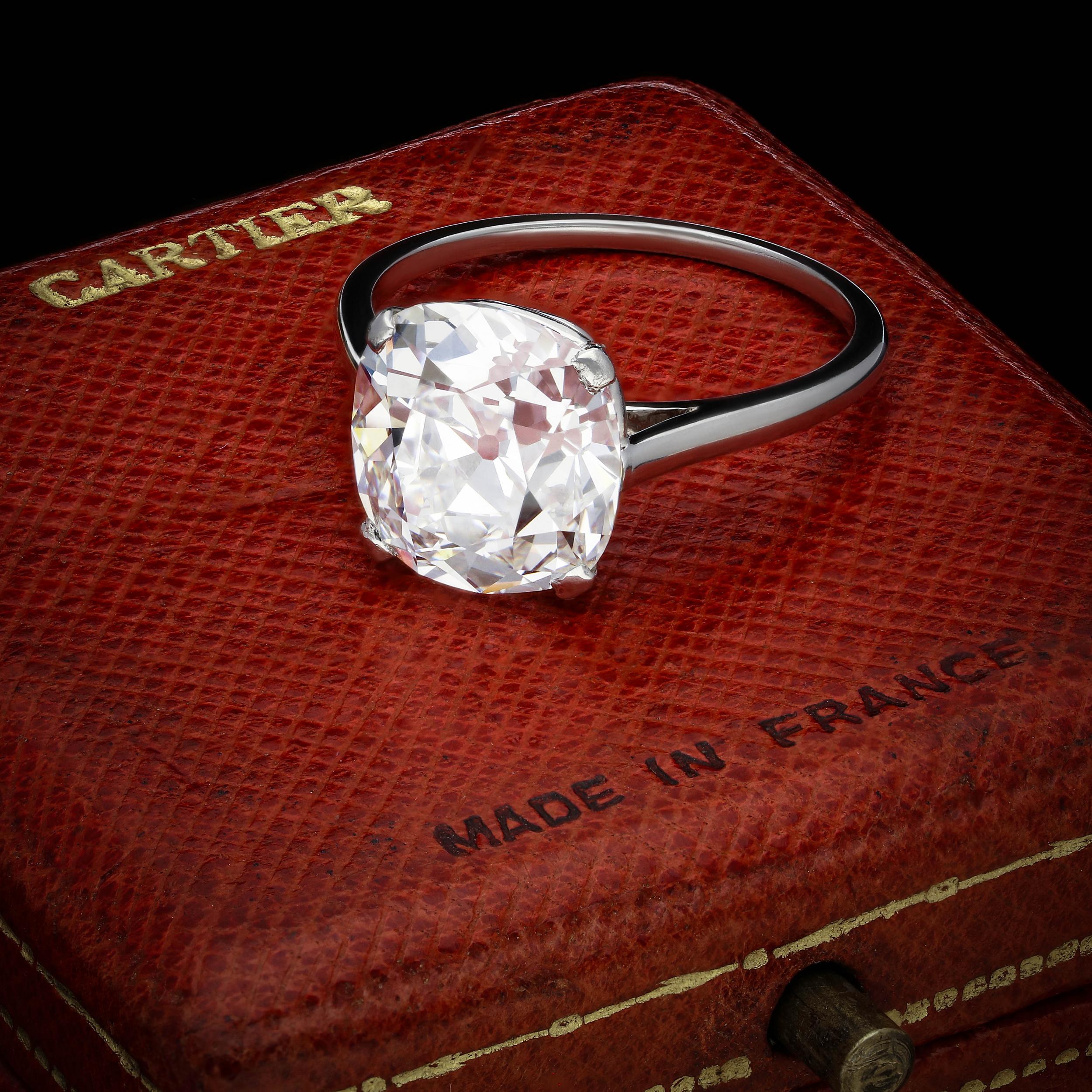 Description
A beautiful old cut diamond solitaire ring by Cartier c.1920s, set with a wonderful bright and lively cushion shaped old mine brilliant cut diamond weighing 4.21cts and of E colour and VS1 clarity, claw set in platinum to a very simple