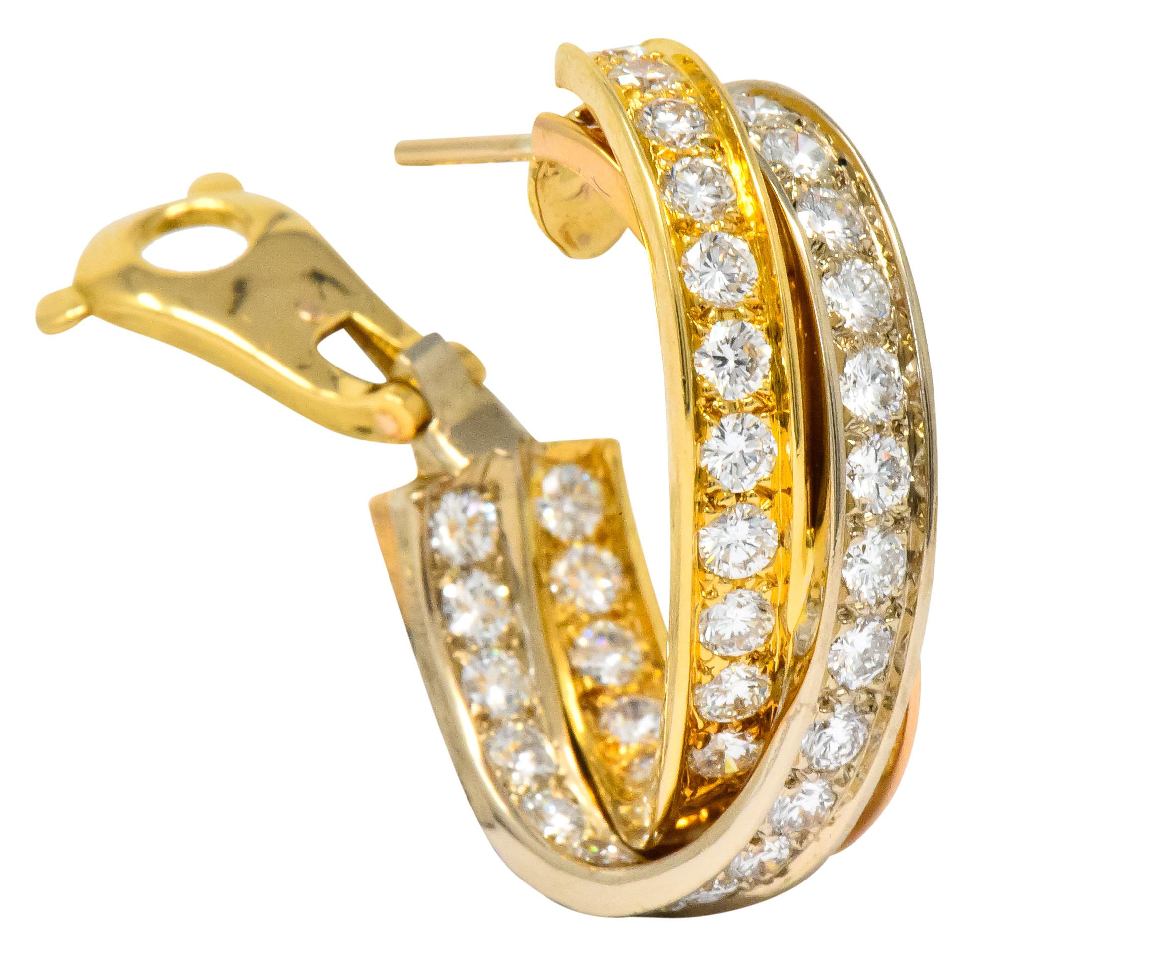 Half hoop design incorporating yellow gold, rose gold, and white gold intertwining channels

Each bead set with round brilliant cut diamonds weighing approximately 5.00 carats total, E/F color and VVS to VS clarity

From Cartier Trinity
